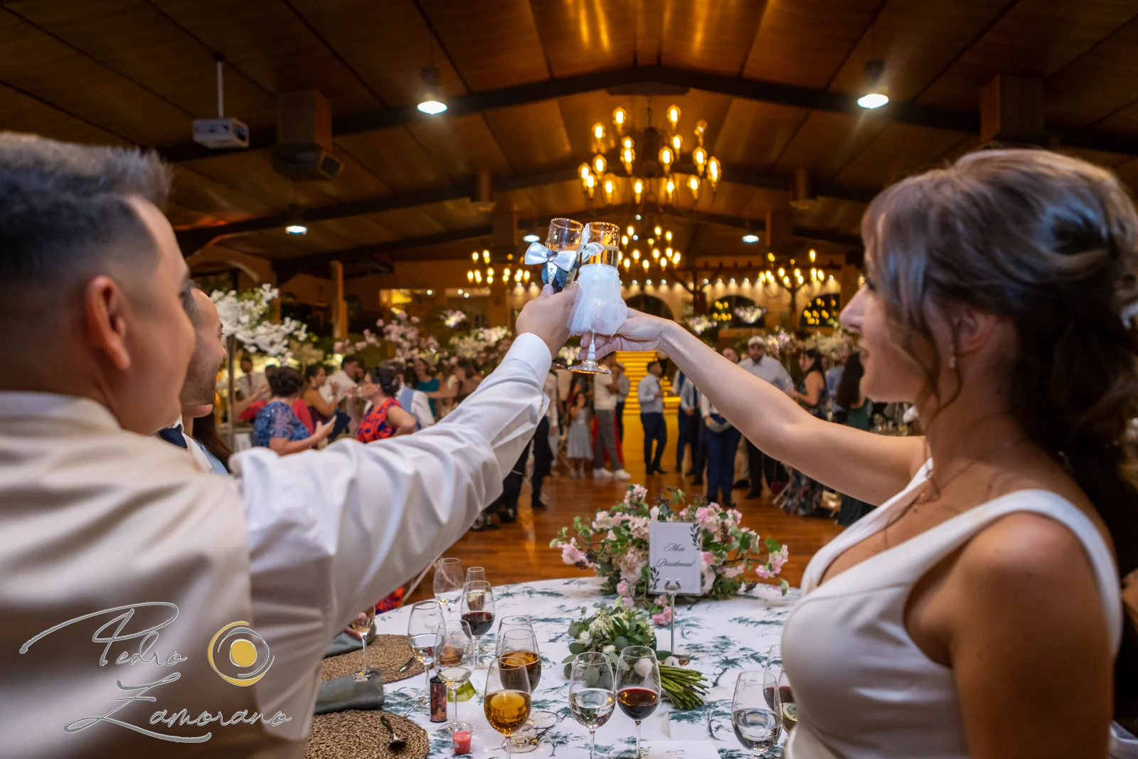 Pareja levantando sus copas durante el brindis del banquete en Hacienda Jacaranda.