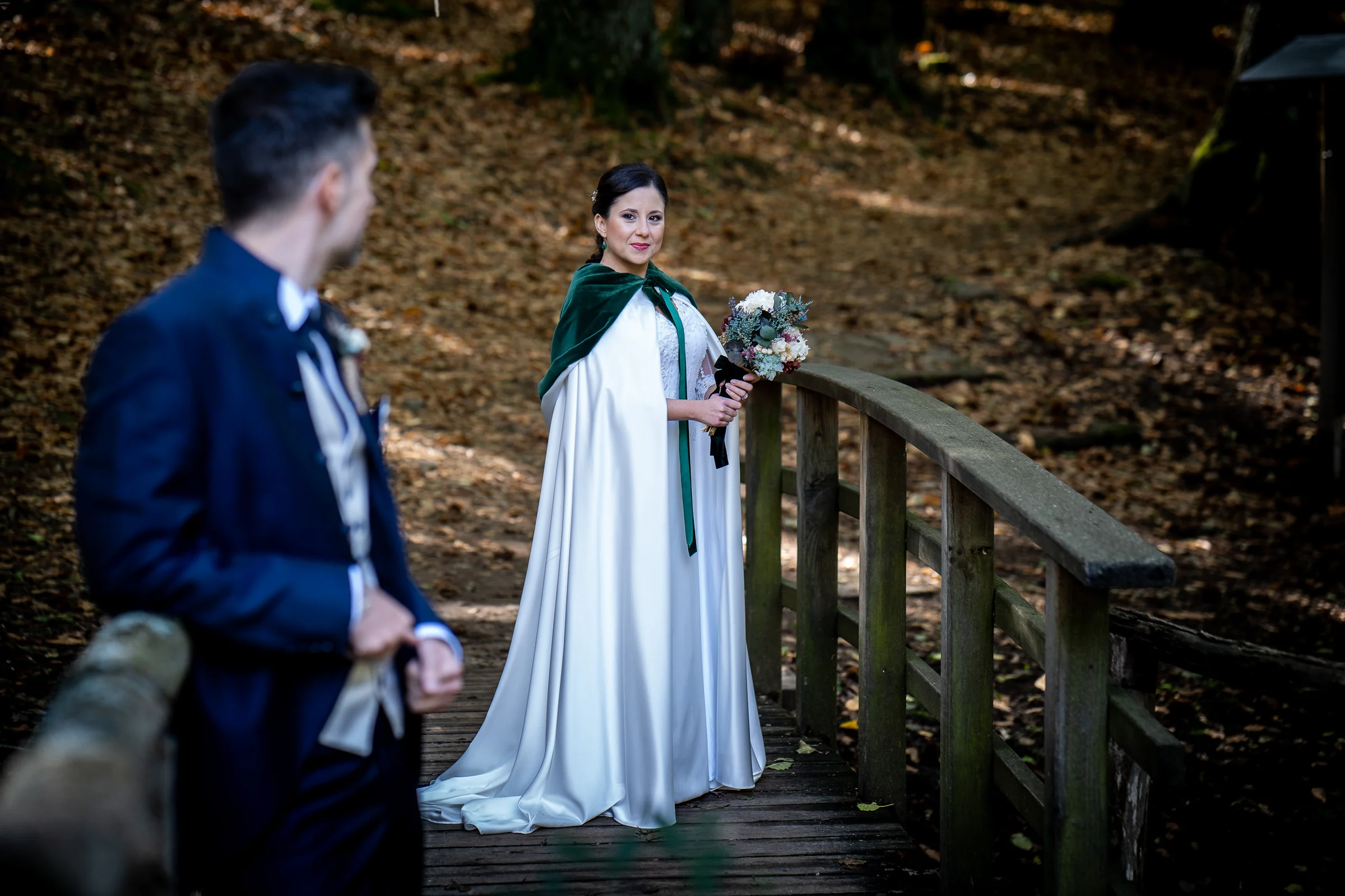 Idoya mira hacia Daniel sobre el puente de madera con el bosque de El Tiemblo al fondo durante su postboda.