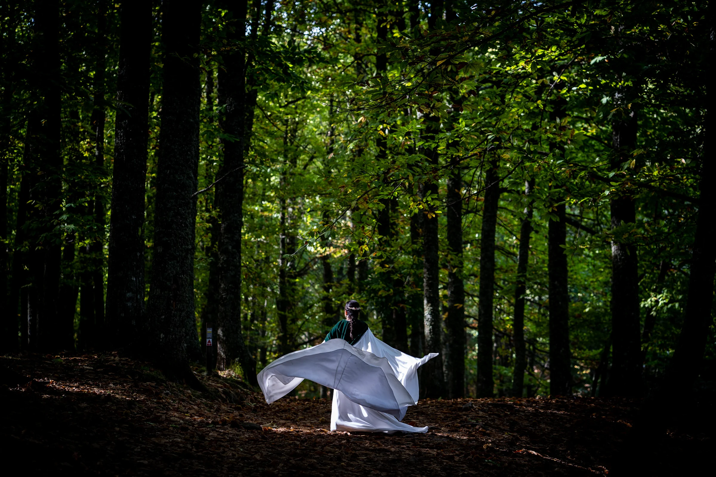Idoya hace girar su capa blanca entre los árboles del Castañar de El Tiemblo durante la sesión de postboda.