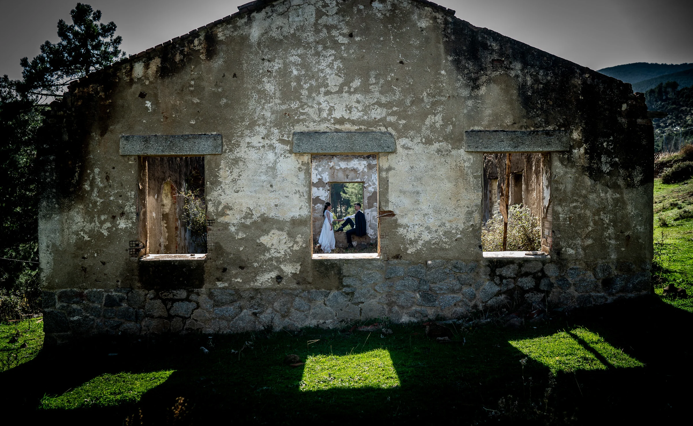 Idoya y Daniel aparecen en la ventana central de un antiguo edificio en ruinas rodeado por el paisaje de El Tiemblo.