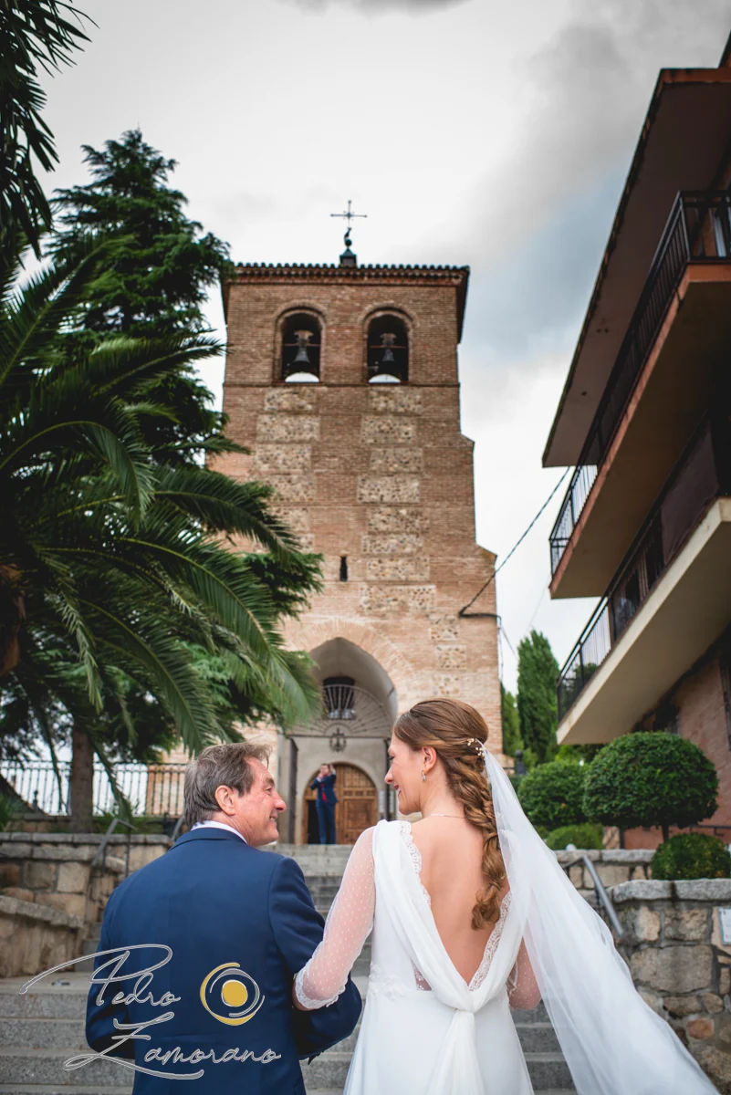 Novia caminando hacia la iglesia acompañada de un familiar y varios niños antes de la ceremonia.