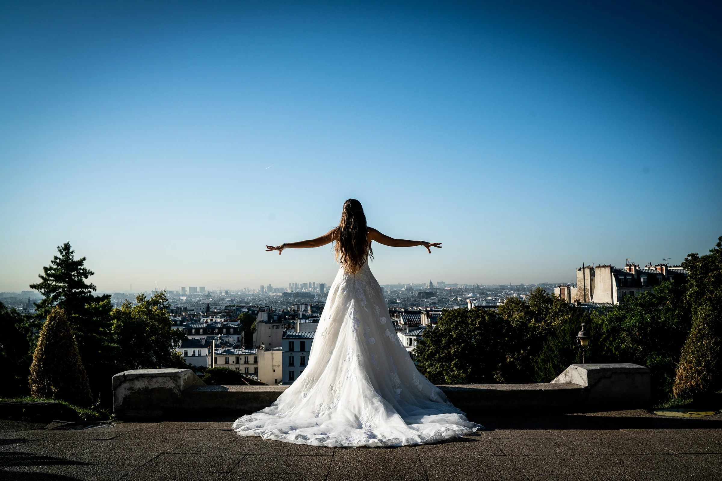 Lara abre los brazos frente al skyline de París en el mirador de Montmartre durante su postboda.