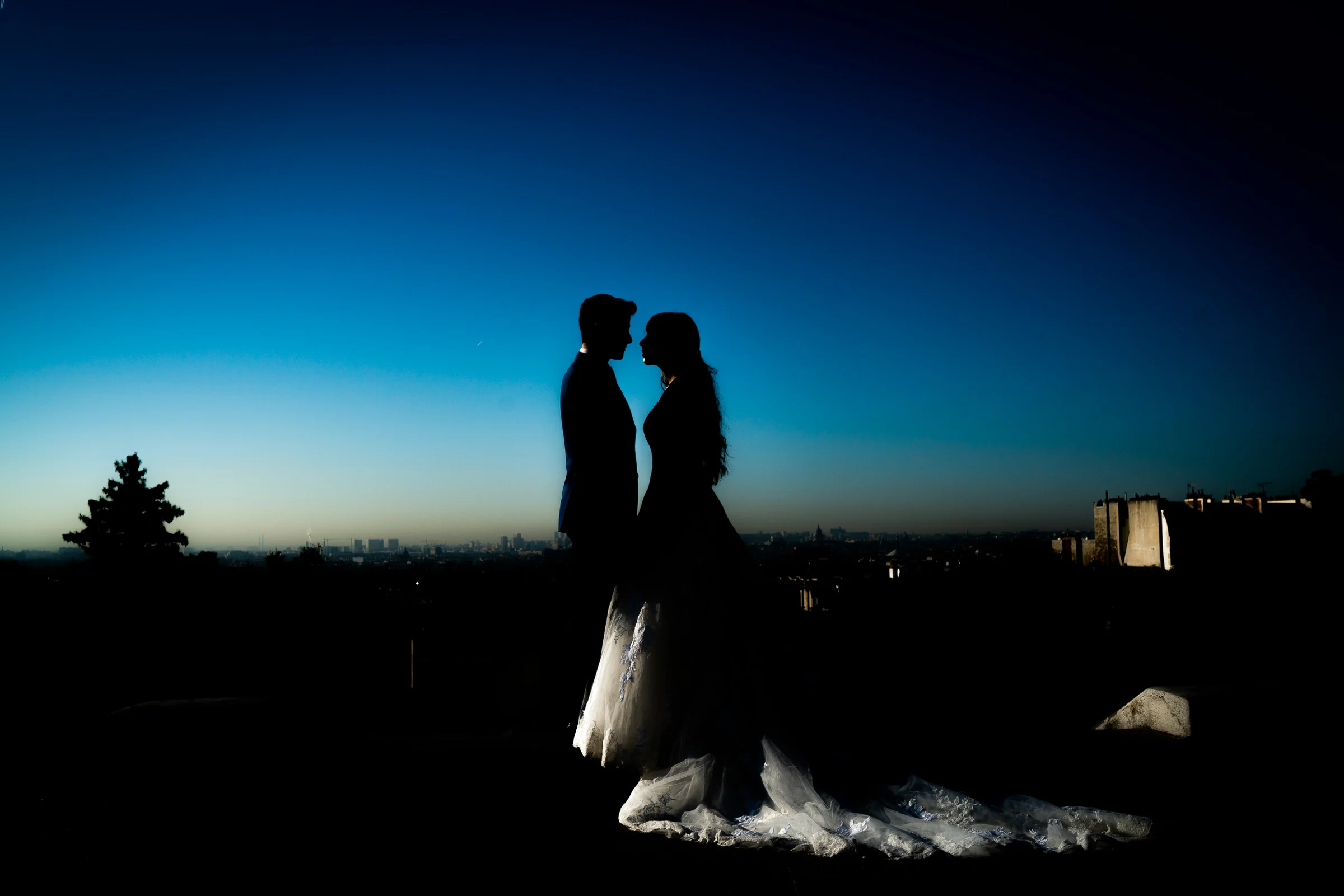 Silueta de José Luis y Lara frente al horizonte de París durante su postboda en Montmartre.