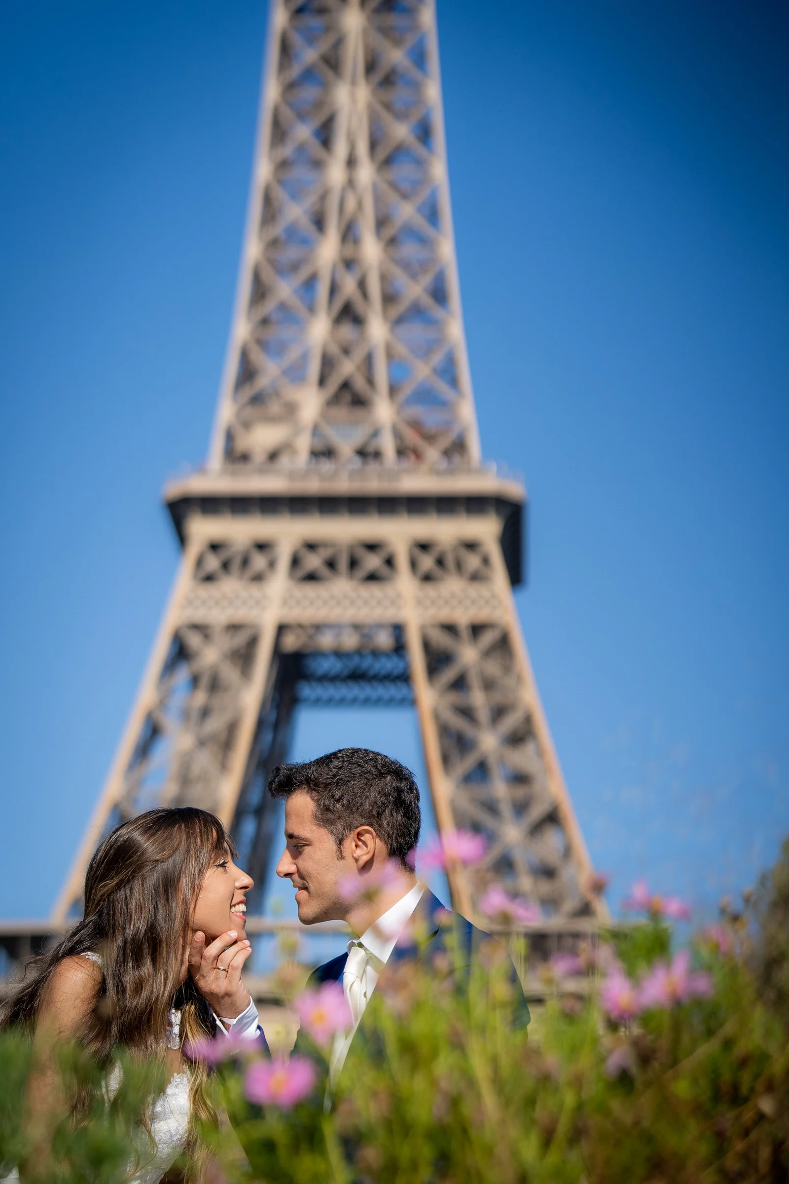 José Luis y Lara se miran entre flores con la Torre Eiffel desenfocada al fondo.