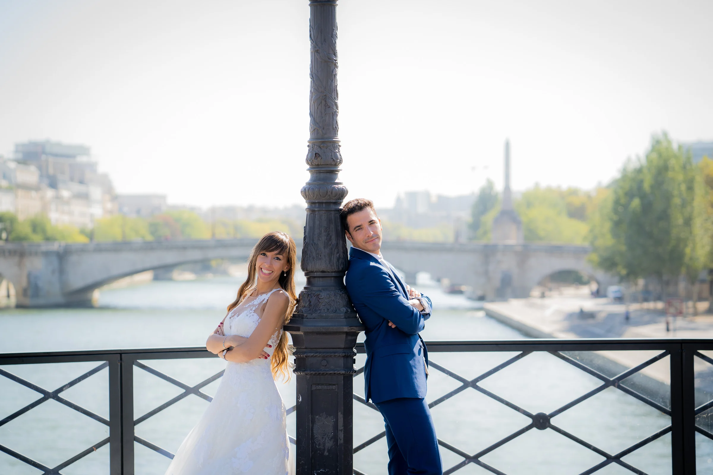 José Luis y Lara posan a ambos lados de una farola en un puente sobre el Sena durante su postboda.