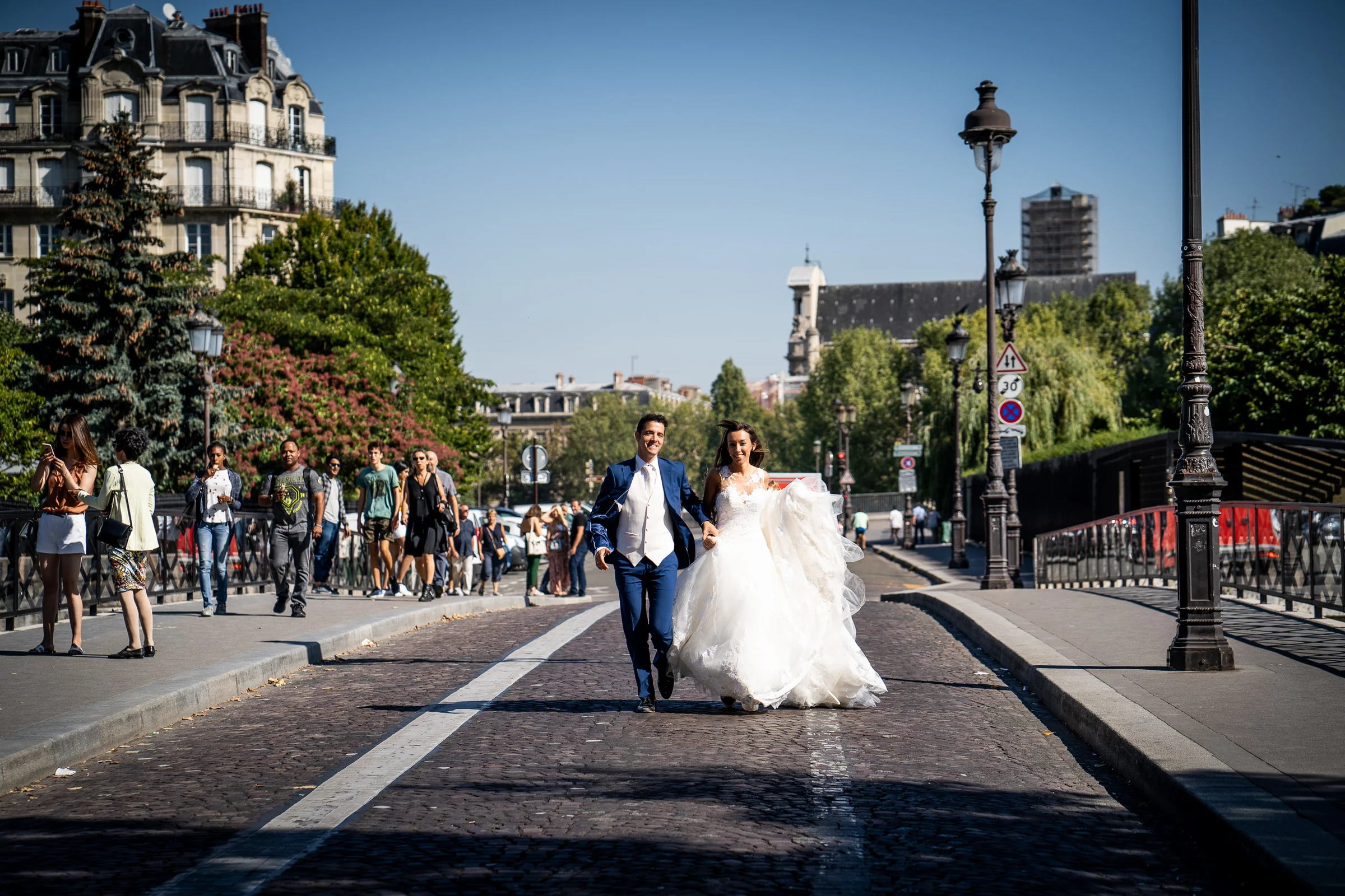 José Luis y Lara corren de la mano por una calle junto al Sena durante su postboda en París.