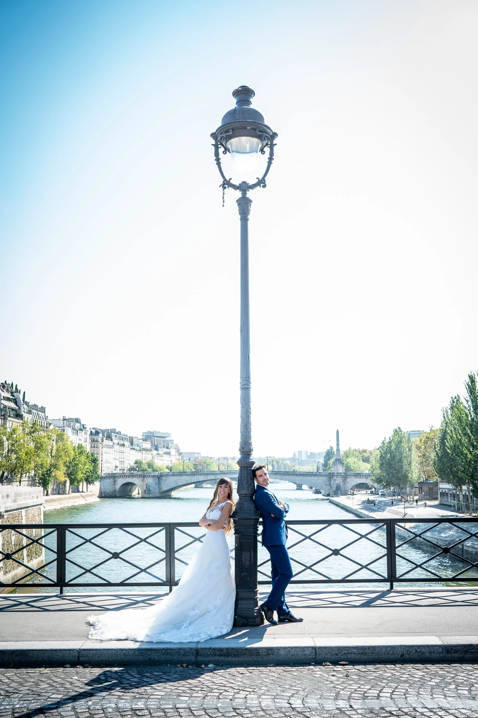José Luis y Lara posan junto a una farola en un puente sobre el Sena con París al fondo.