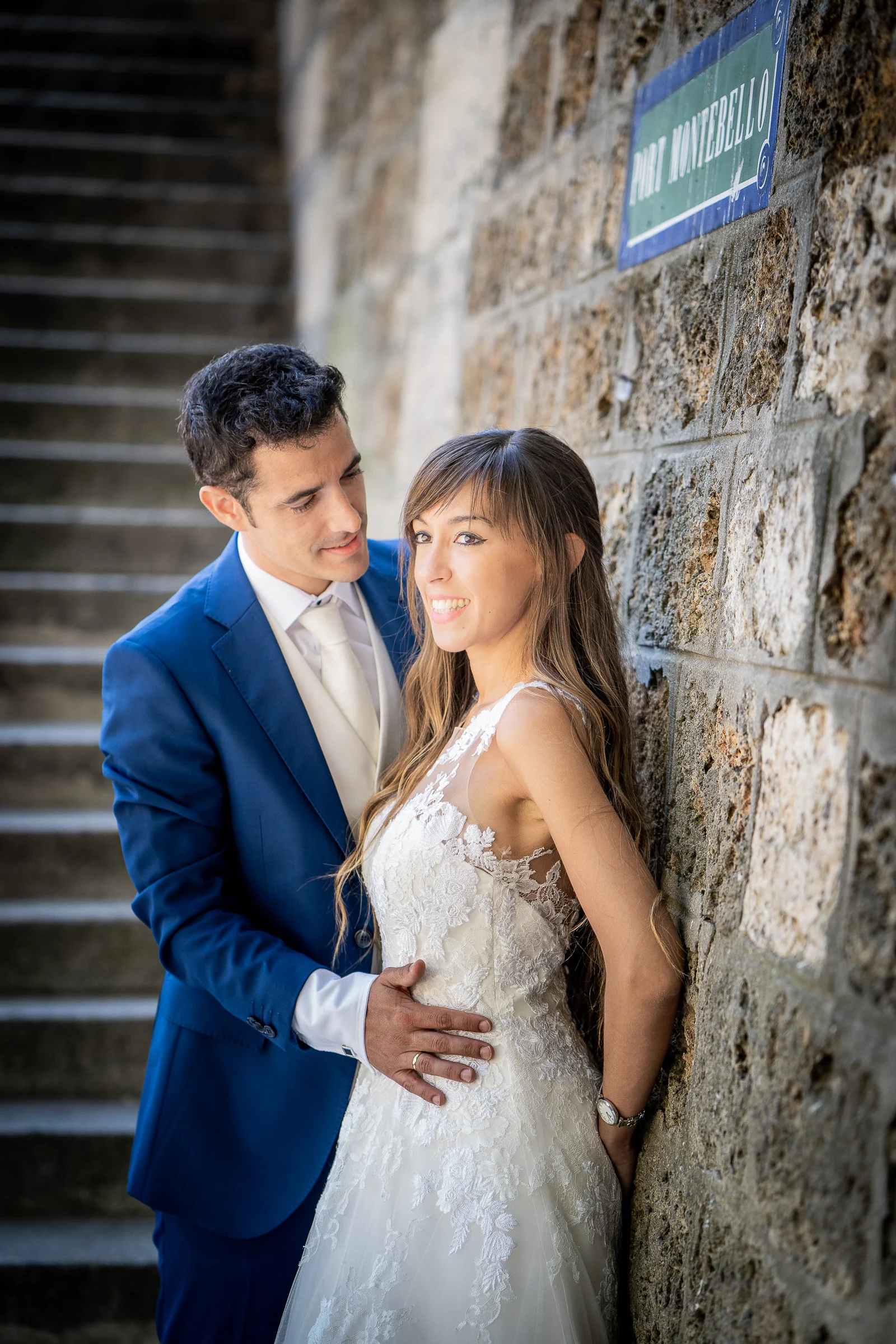 José Luis abraza a Lara junto al muro de piedra de Port de Montebello durante su postboda.