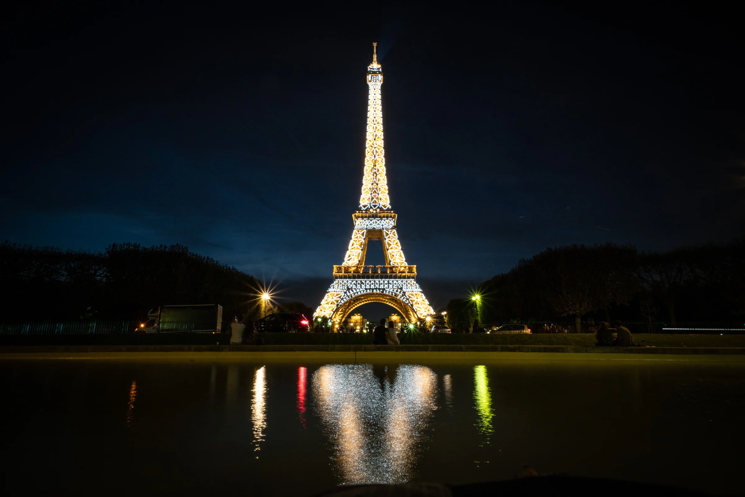 Torre Eiffel iluminada de noche reflejada en el agua durante la postboda de José Luis y Lara en París.