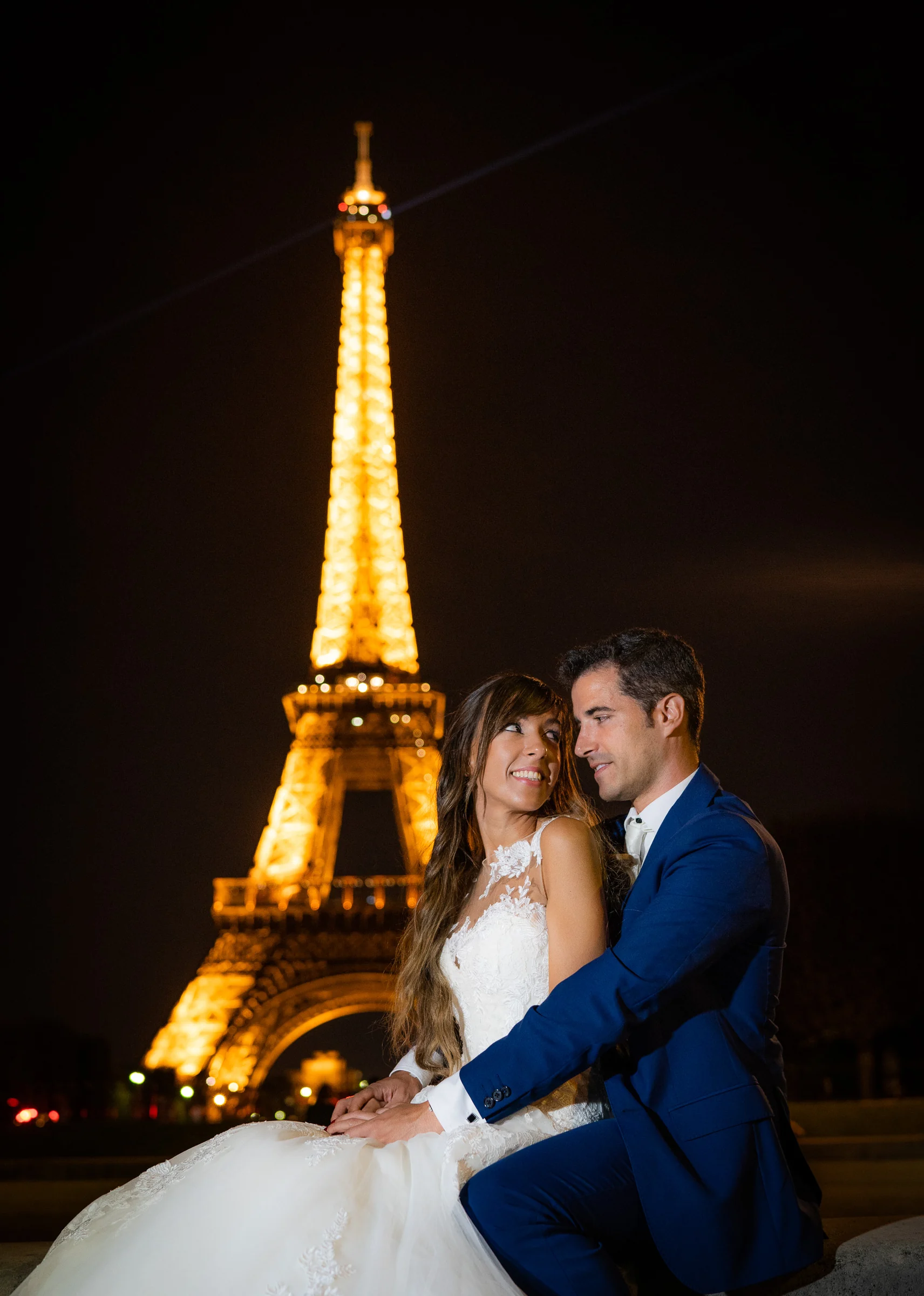 José Luis y Lara abrazados de noche con la Torre Eiffel iluminada detrás durante su postboda en París.
