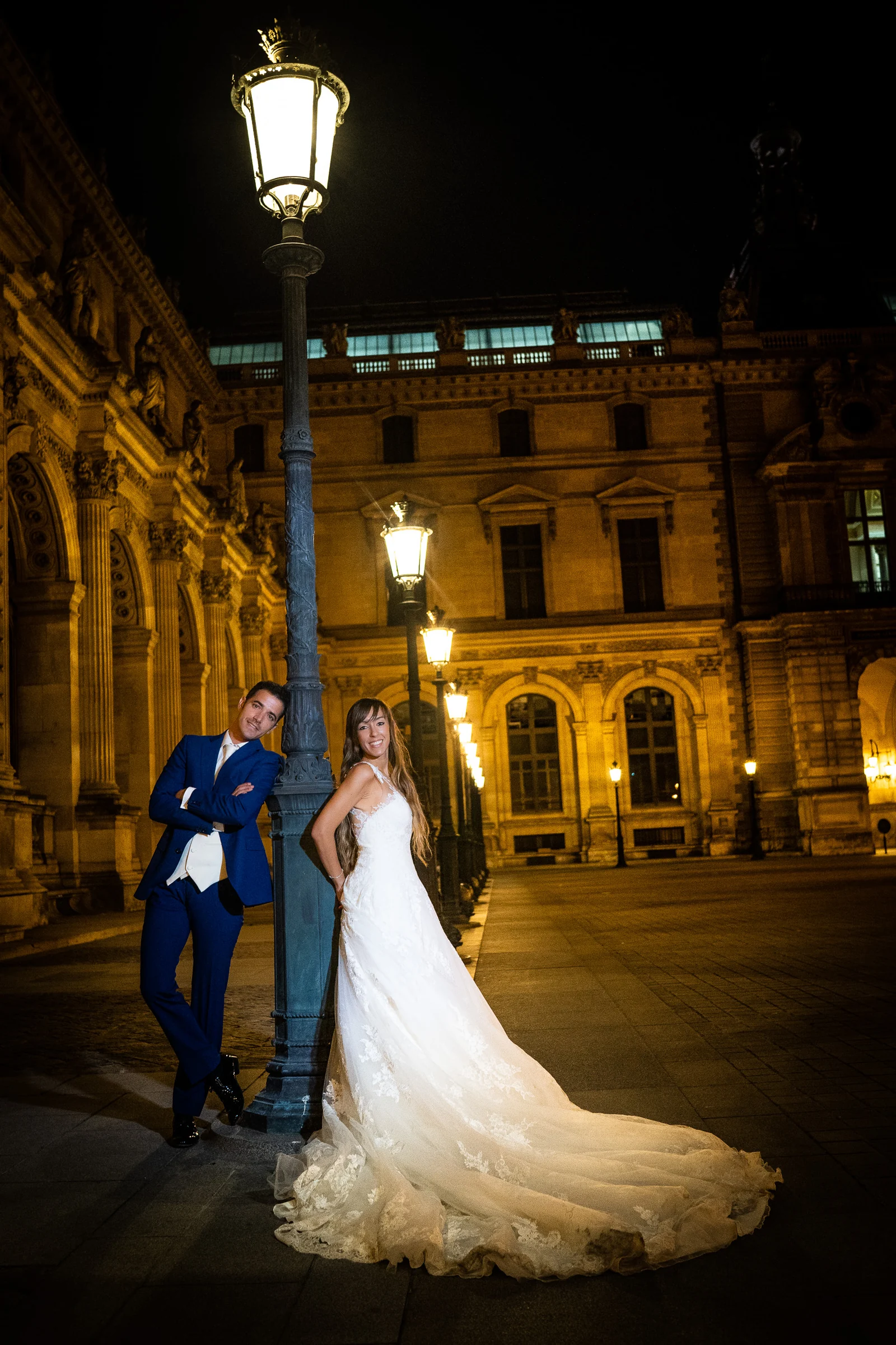 José Luis y Lara posan junto a una farola iluminada en el patio del Louvre durante su postboda nocturna.