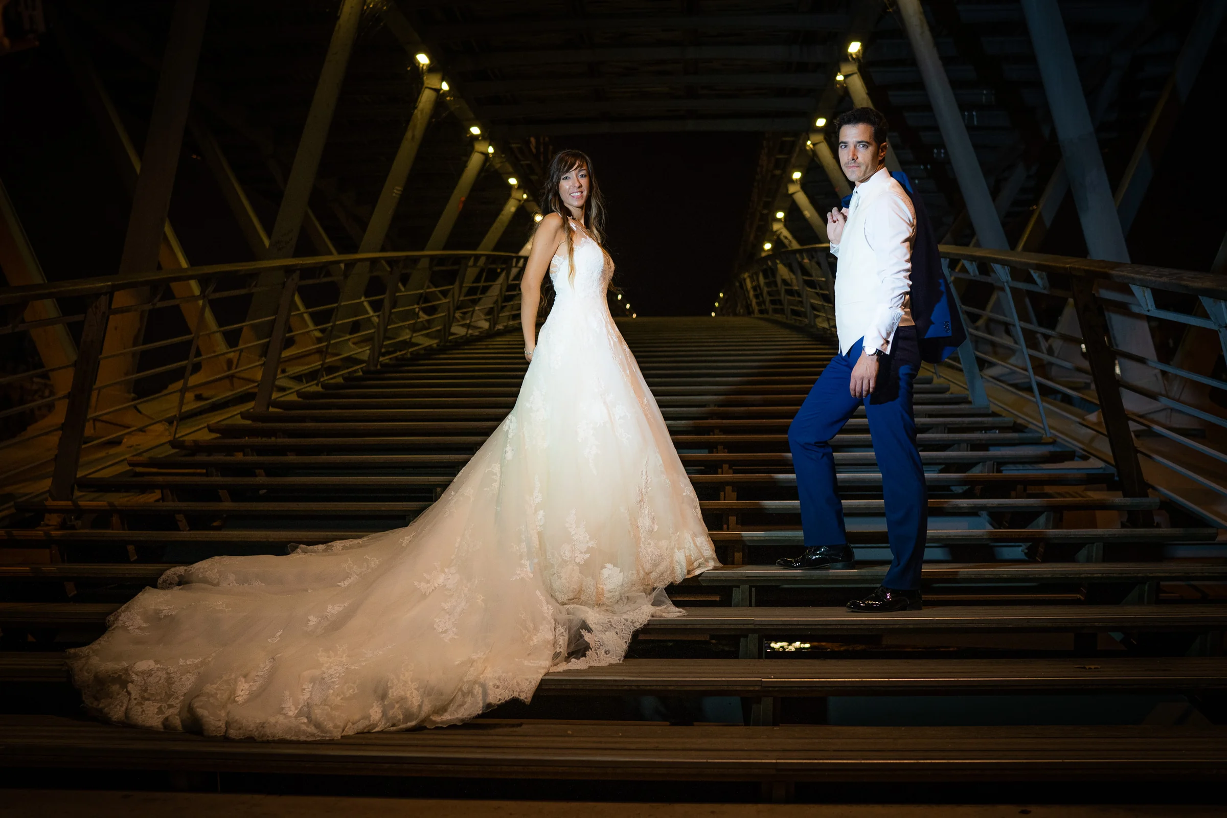 José Luis y Lara posan sobre una escalera metálica iluminada durante su postboda nocturna en París.