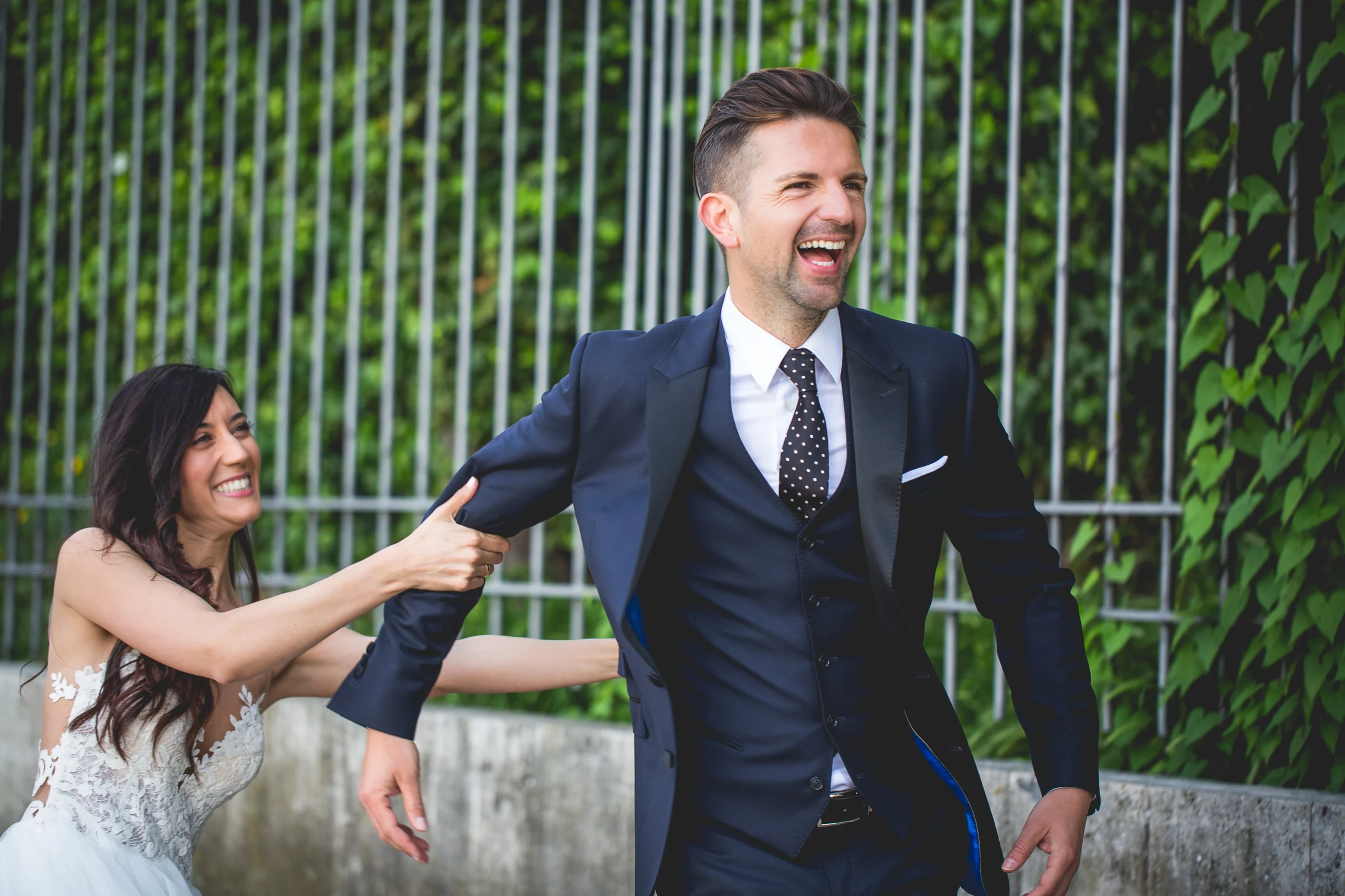 La pareja ríe y juega en un jardín durante la sesión postboda durante una sesión postboda en Jardines y miradores de Roma.