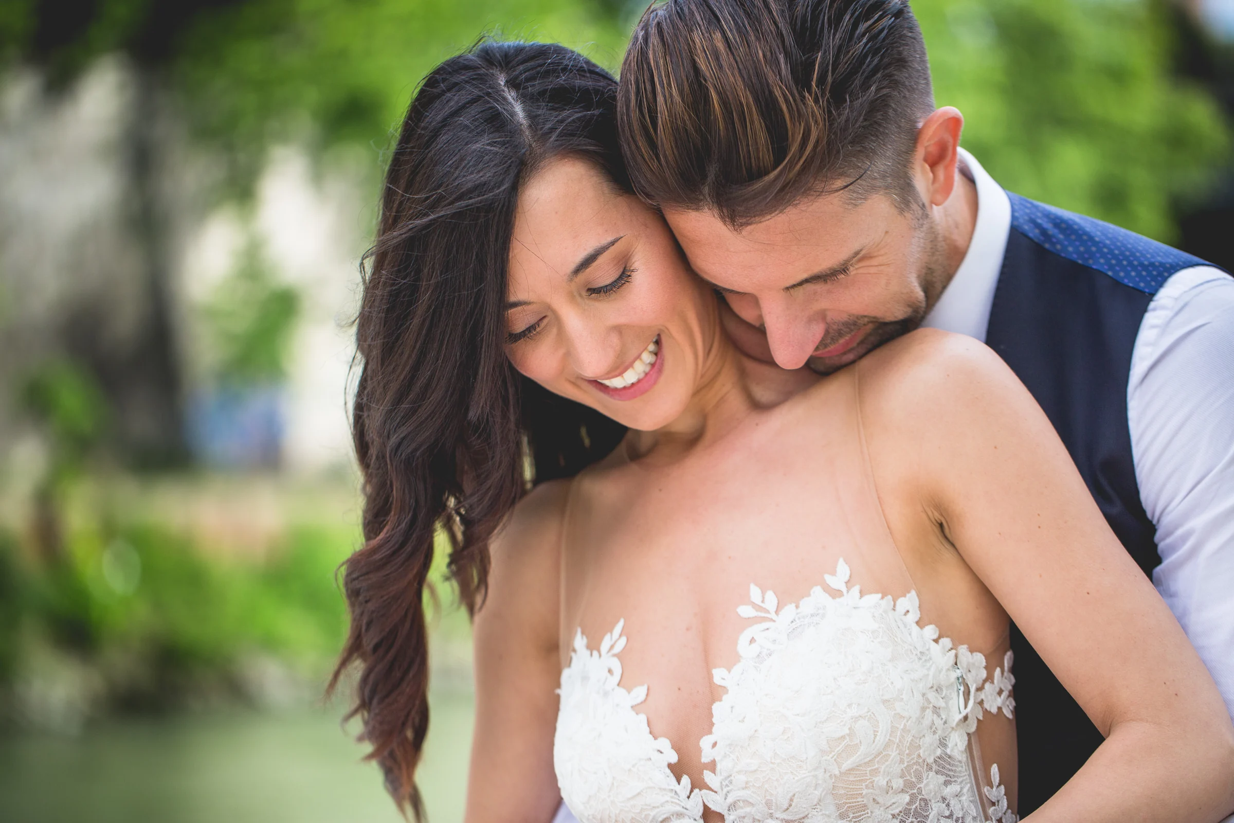 Primer plano íntimo de los novios abrazados junto al río durante una sesión postboda en Río Tíber y puentes de Roma.