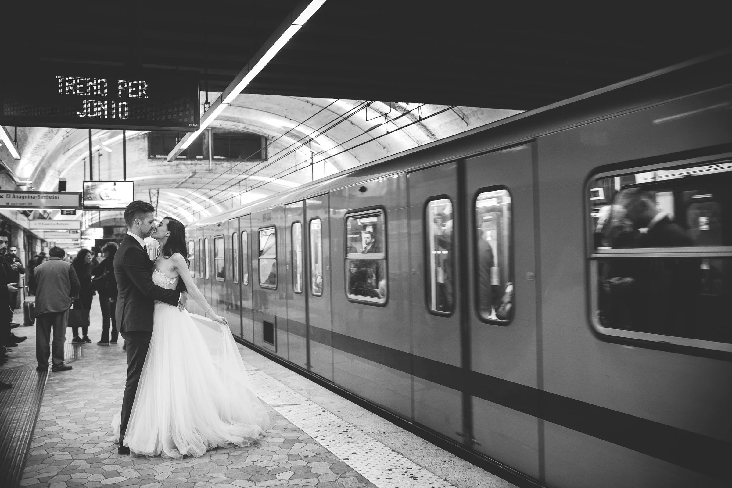 Los novios se besan en blanco y negro en una estación de metro romana durante una sesión postboda en Metro de Roma.