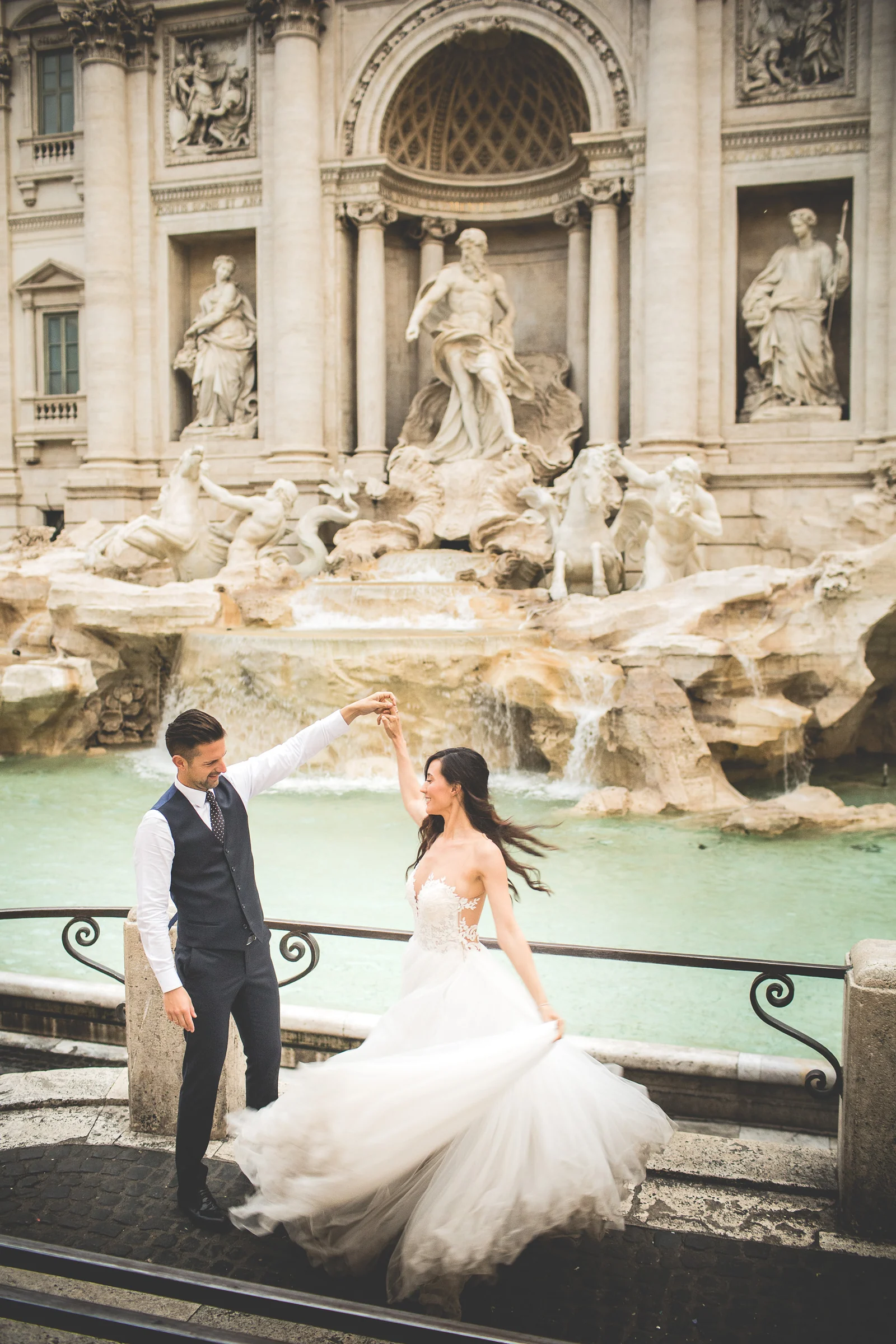 La pareja baila junto al borde de la Fontana di Trevi durante una sesión postboda en Fontana di Trevi.