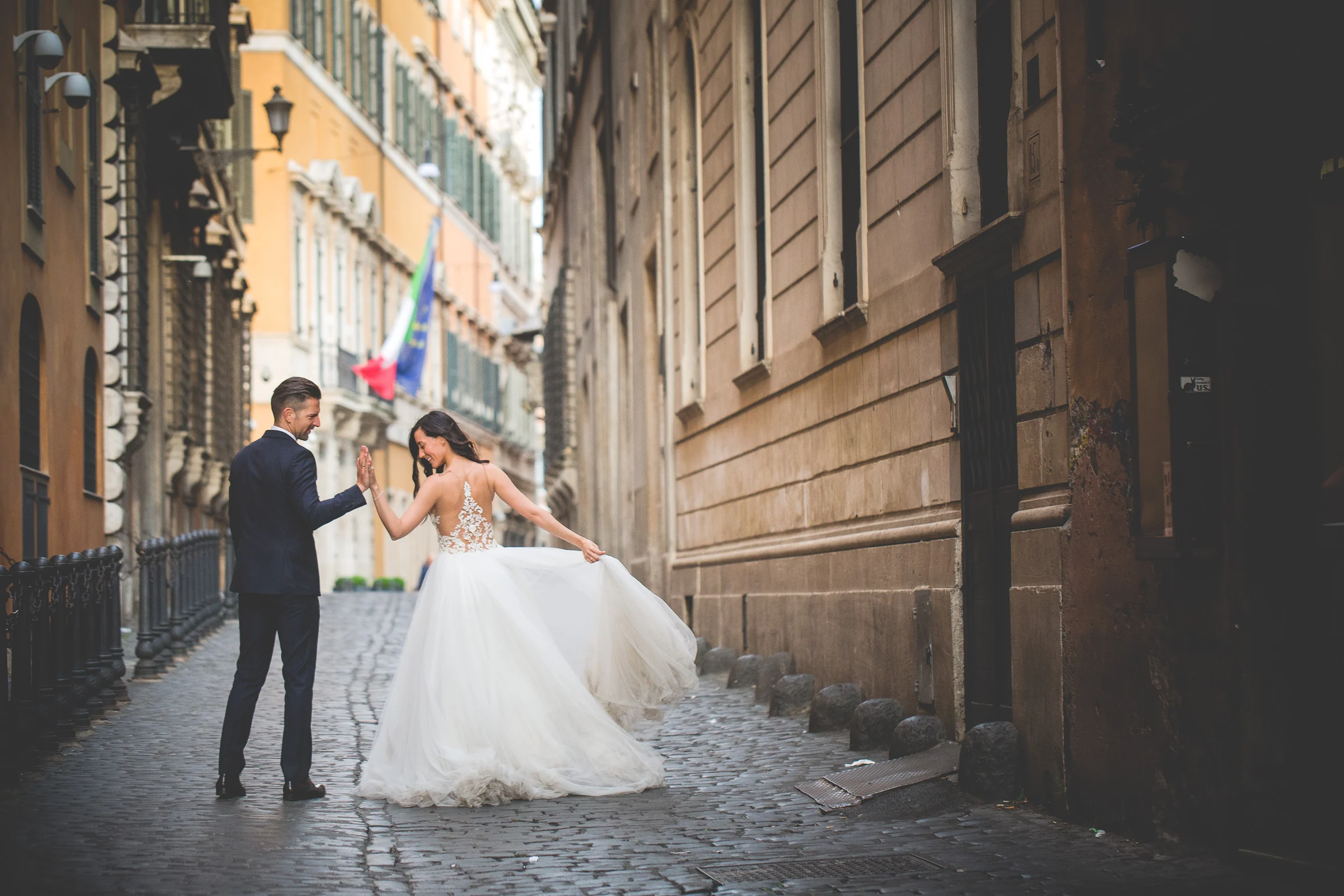 Los novios juegan en una calle adoquinada cercana al Panteón durante una sesión postboda en Panteón de Roma.