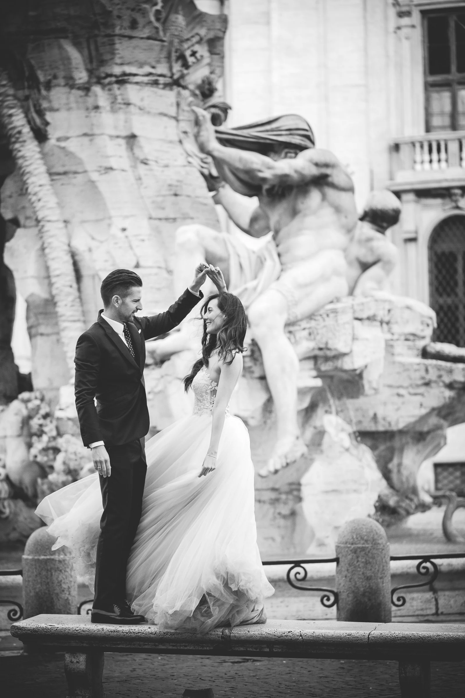 Retrato en blanco y negro de los novios bailando en Piazza Navona durante una sesión postboda en Piazza Navona.