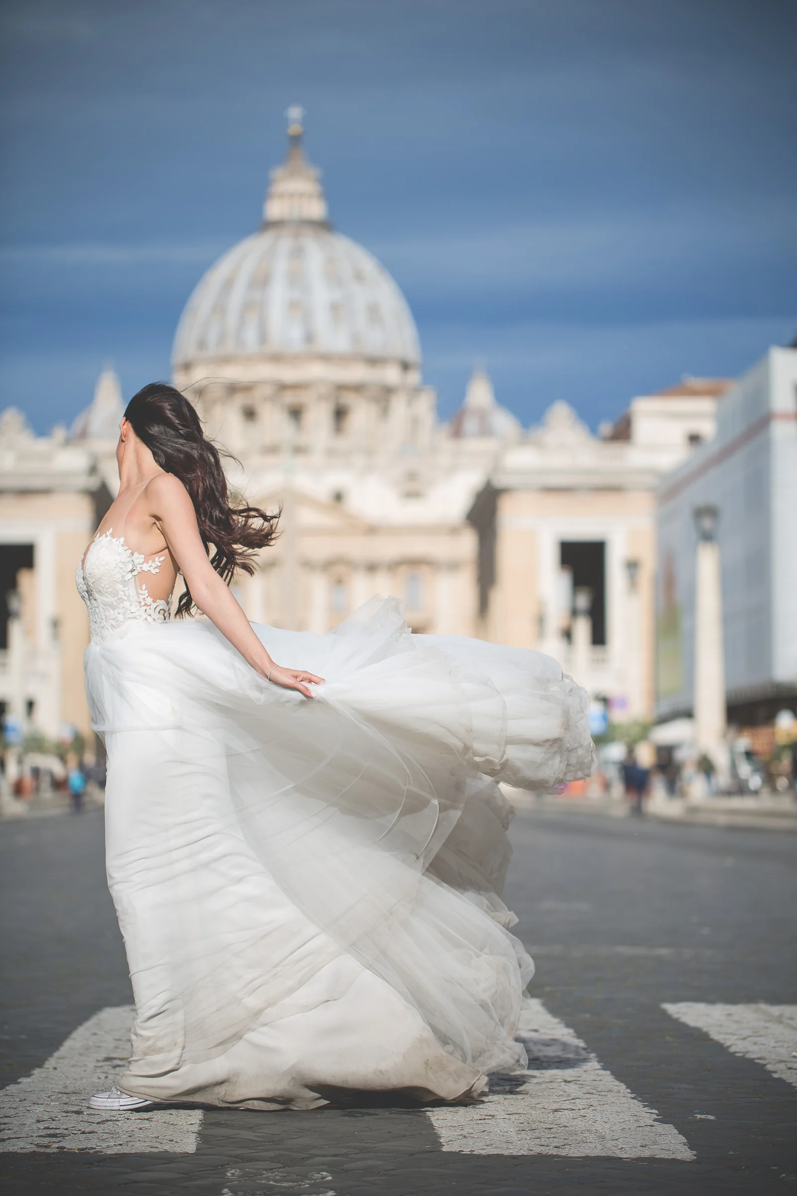 La novia gira el vestido frente a la Basílica de San Pedro durante una sesión postboda en Vaticano y Plaza de San Pedro.