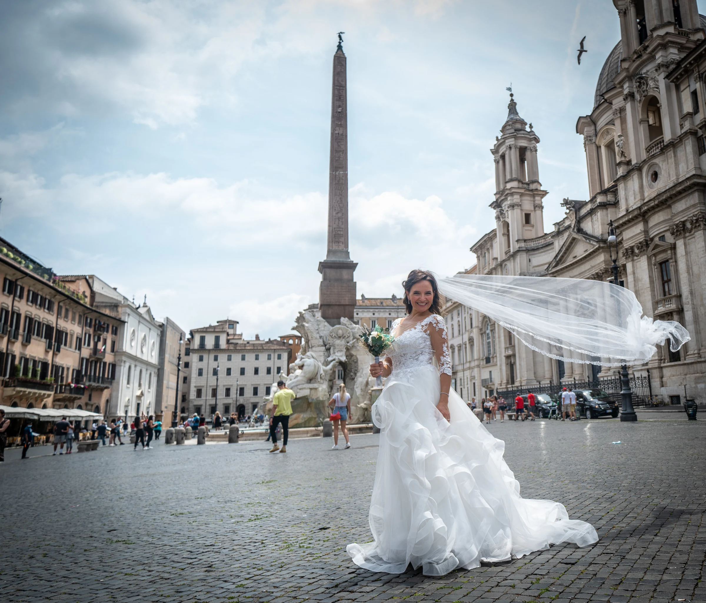 Esther mueve el velo frente a la arquitectura barroca de Piazza Navona en una fotografía luminosa y elegante de la postboda.