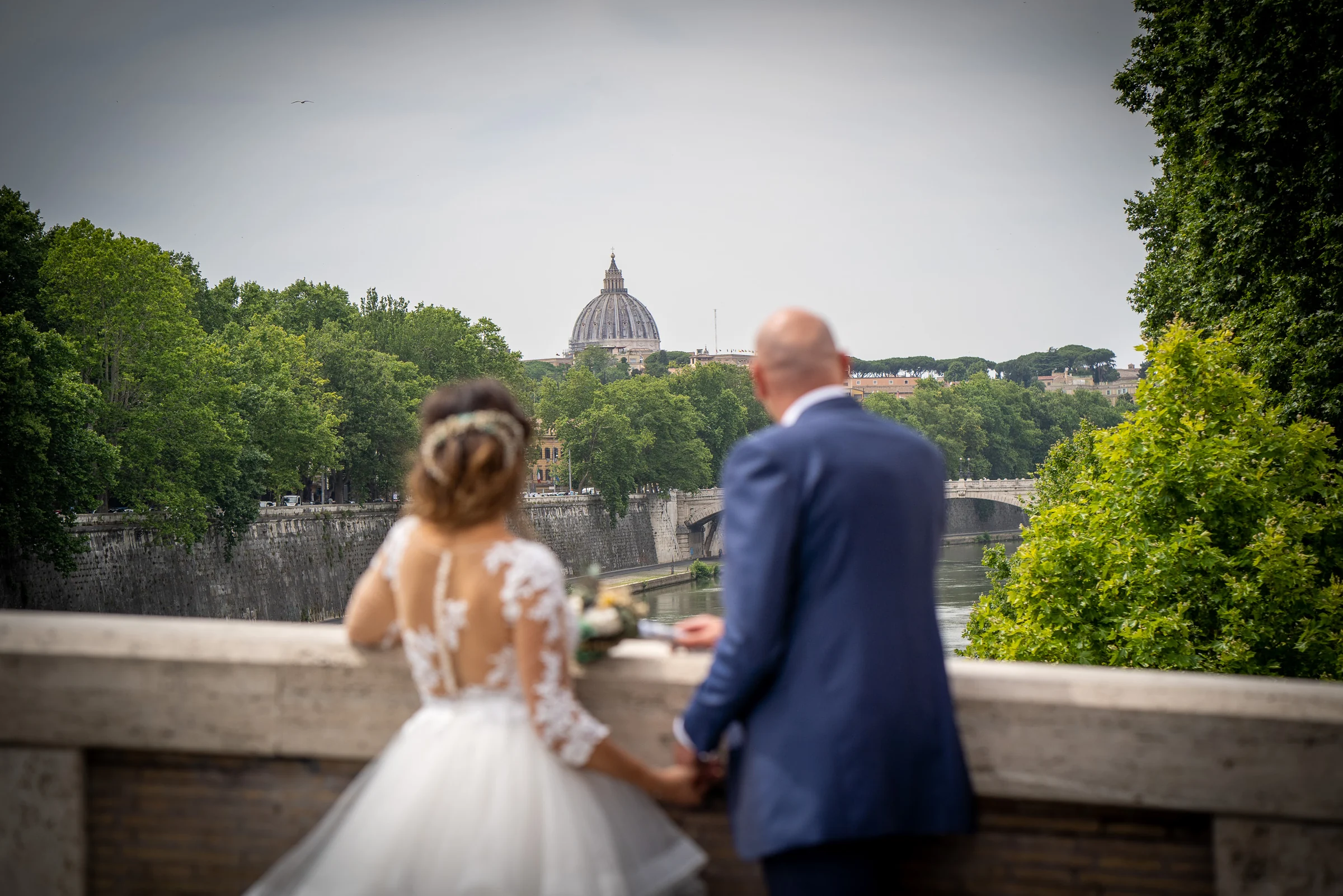 Marco y Esther contemplan la cúpula de San Pedro desde un mirador sobre el Tíber durante su postboda en Roma.