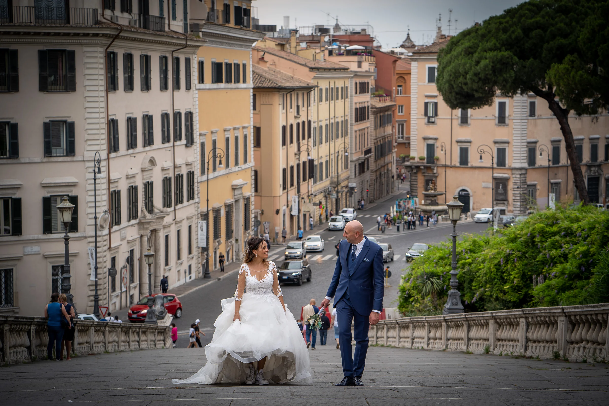 Marco y Esther suben una gran escalinata con vistas a las calles y tejados del centro de Roma.