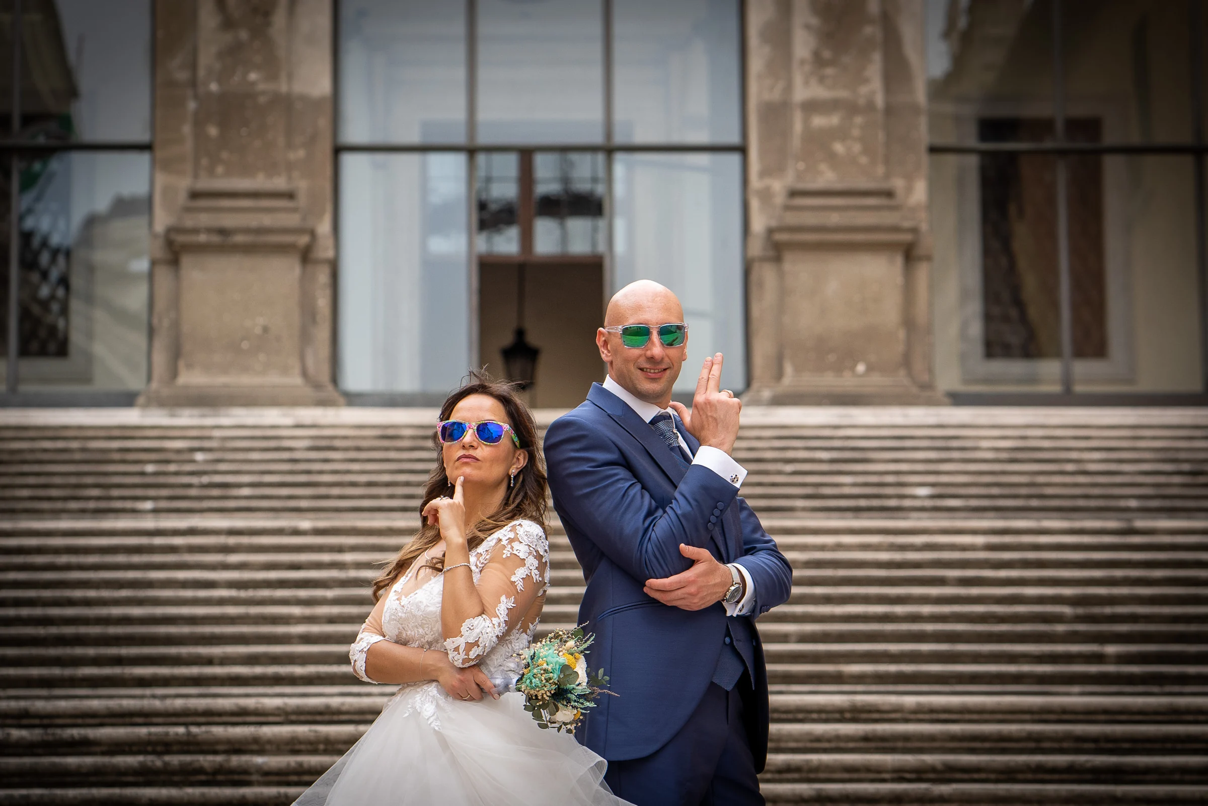 Marco y Esther posan con gafas de sol y actitud divertida en una escalinata monumental de Roma.