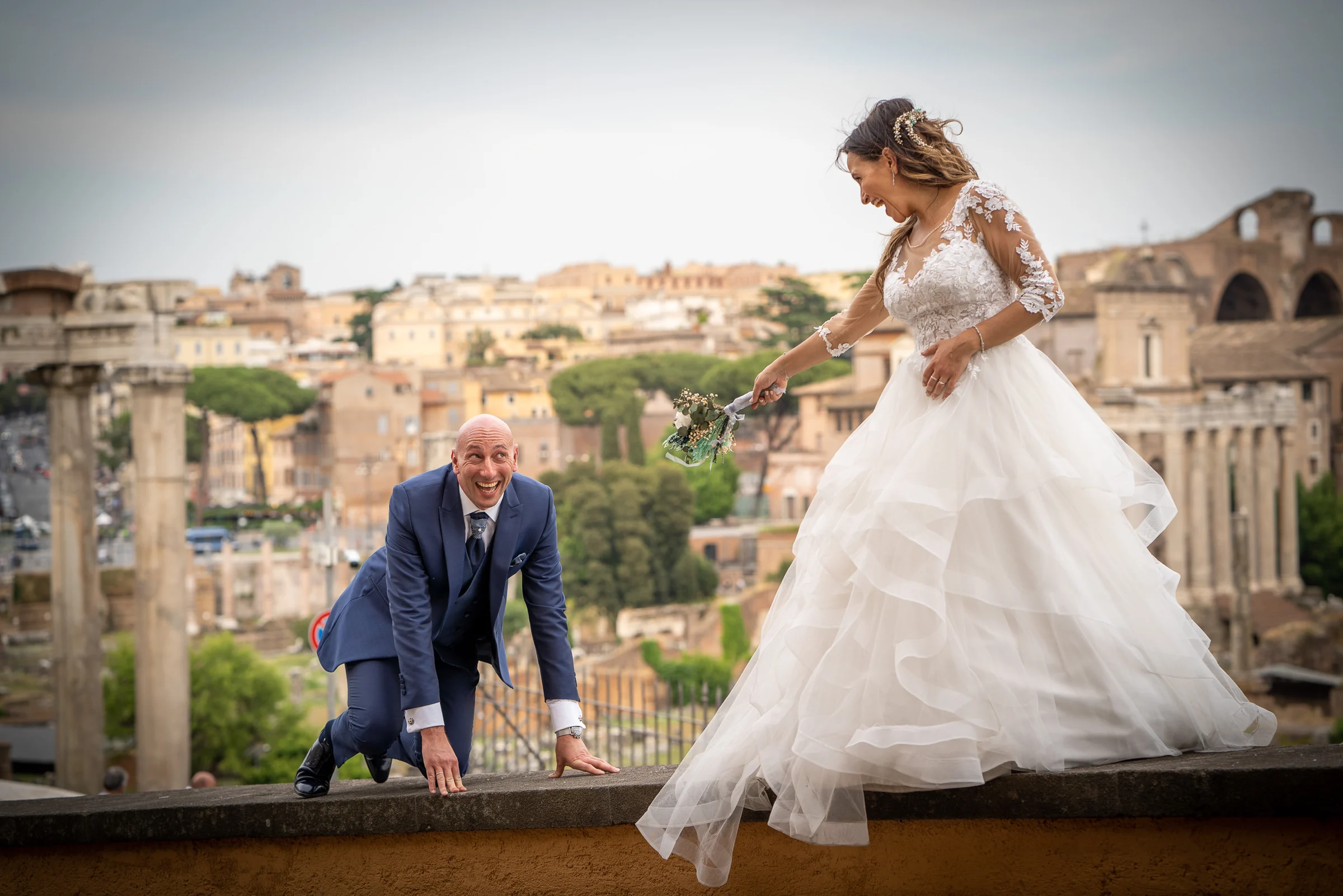 Marco y Esther juegan en un mirador sobre el Foro Romano, con ruinas y tejados históricos al fondo.