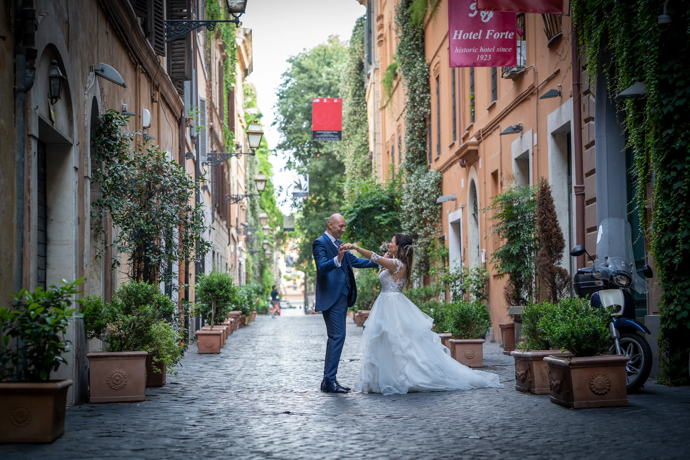 Marco y Esther bailan en una calle adoquinada y verde del centro histórico de Roma durante su postboda.