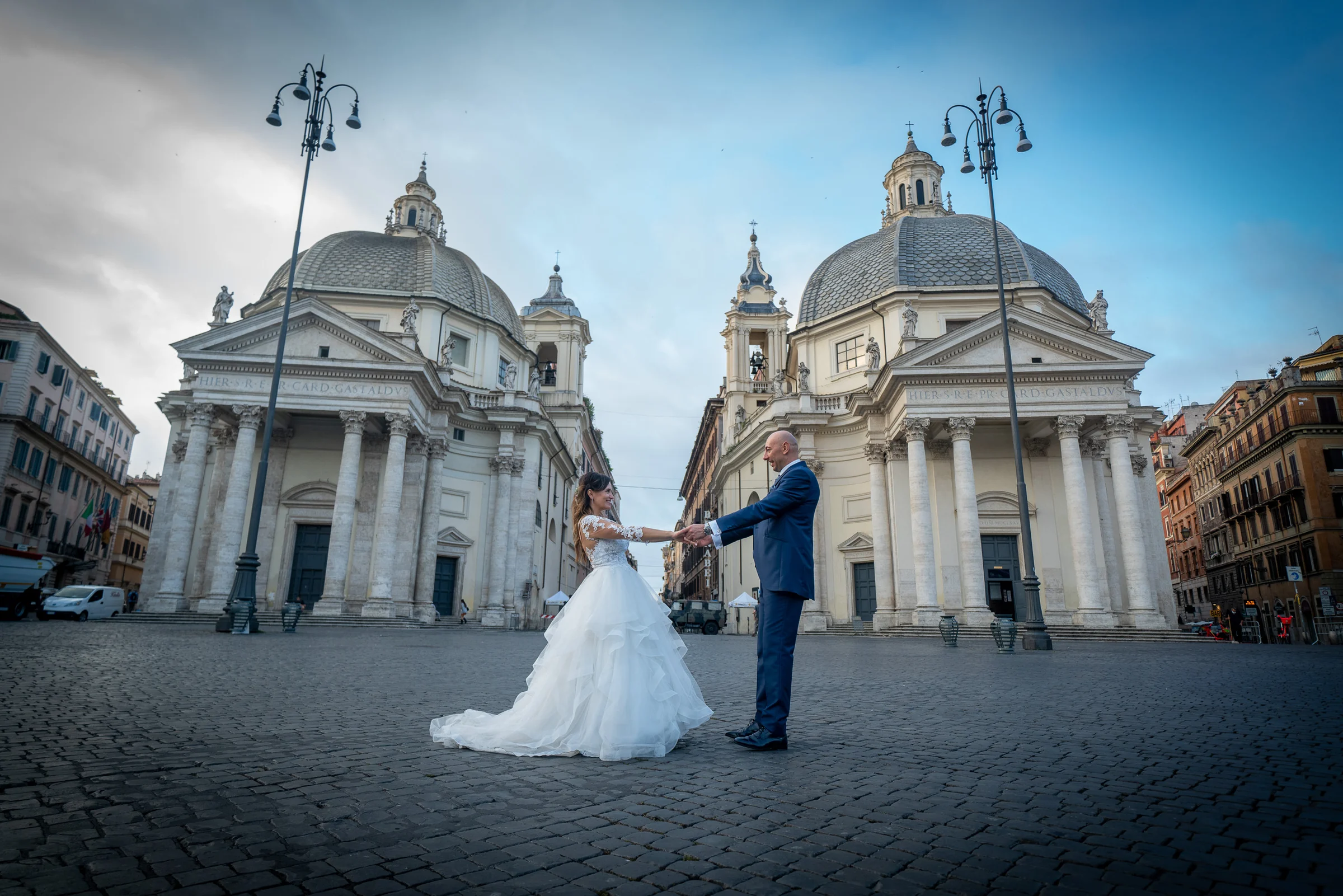 Marco y Esther se toman de la mano en Piazza del Popolo, entre las iglesias gemelas y la gran plaza romana.