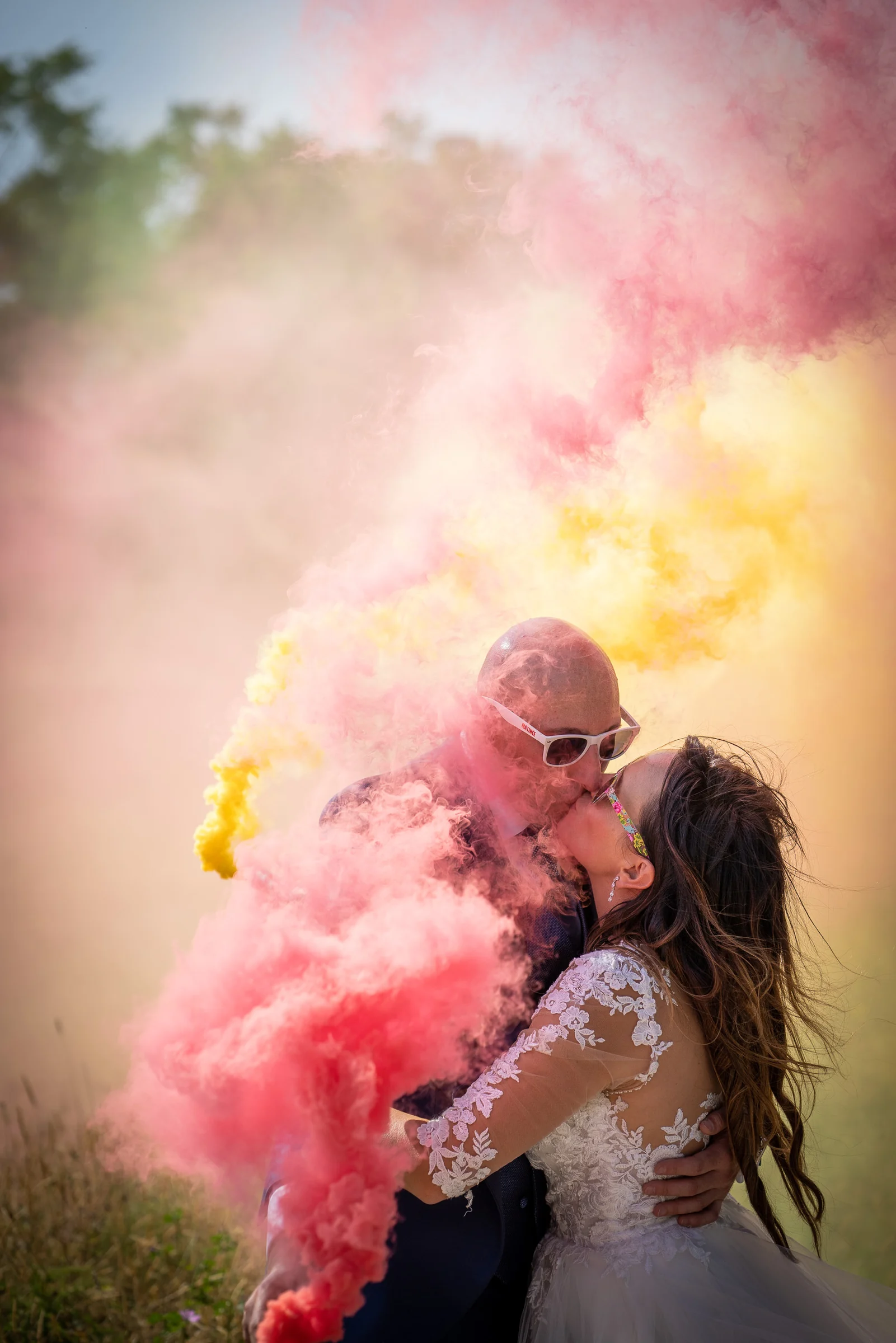 Marco y Esther se besan rodeados por humo de colores al final de su sesión postboda en Roma.