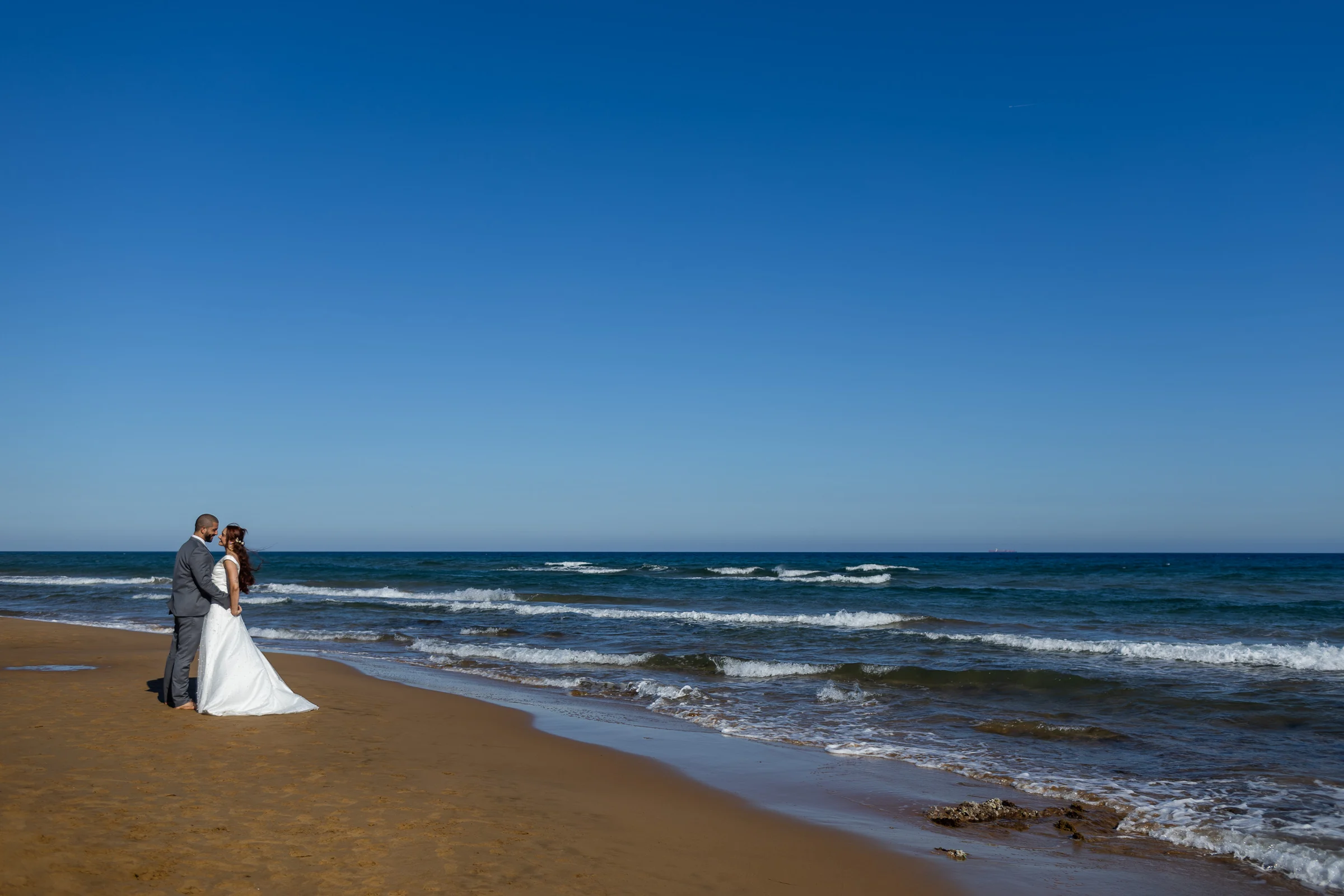 Noemí y Fran se abrazan en la playa con el mar y la arena de Cartagena alrededor.