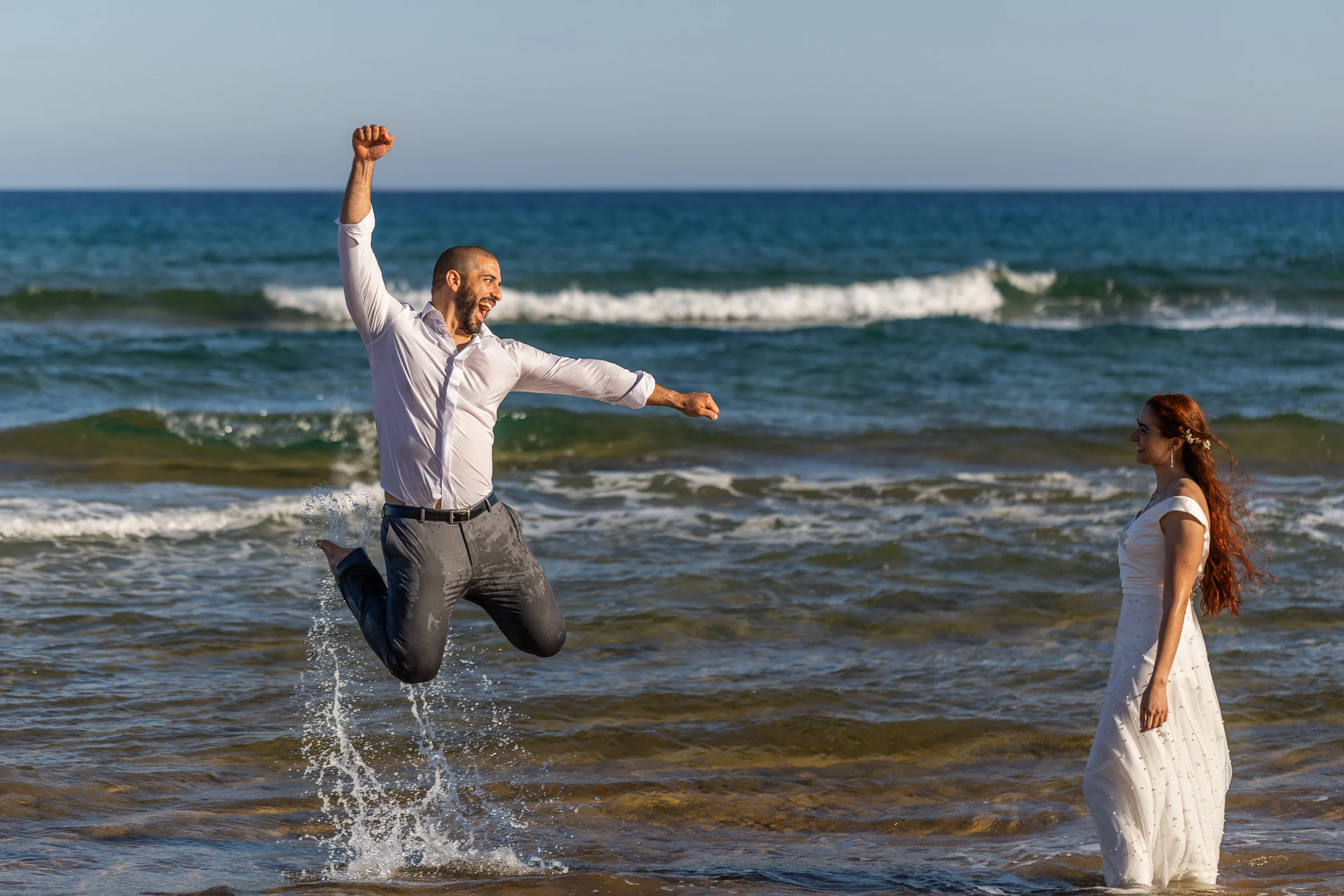 Fran salta en el agua con el puño en alto mientras Noemí lo mira durante su postboda en Cartagena.