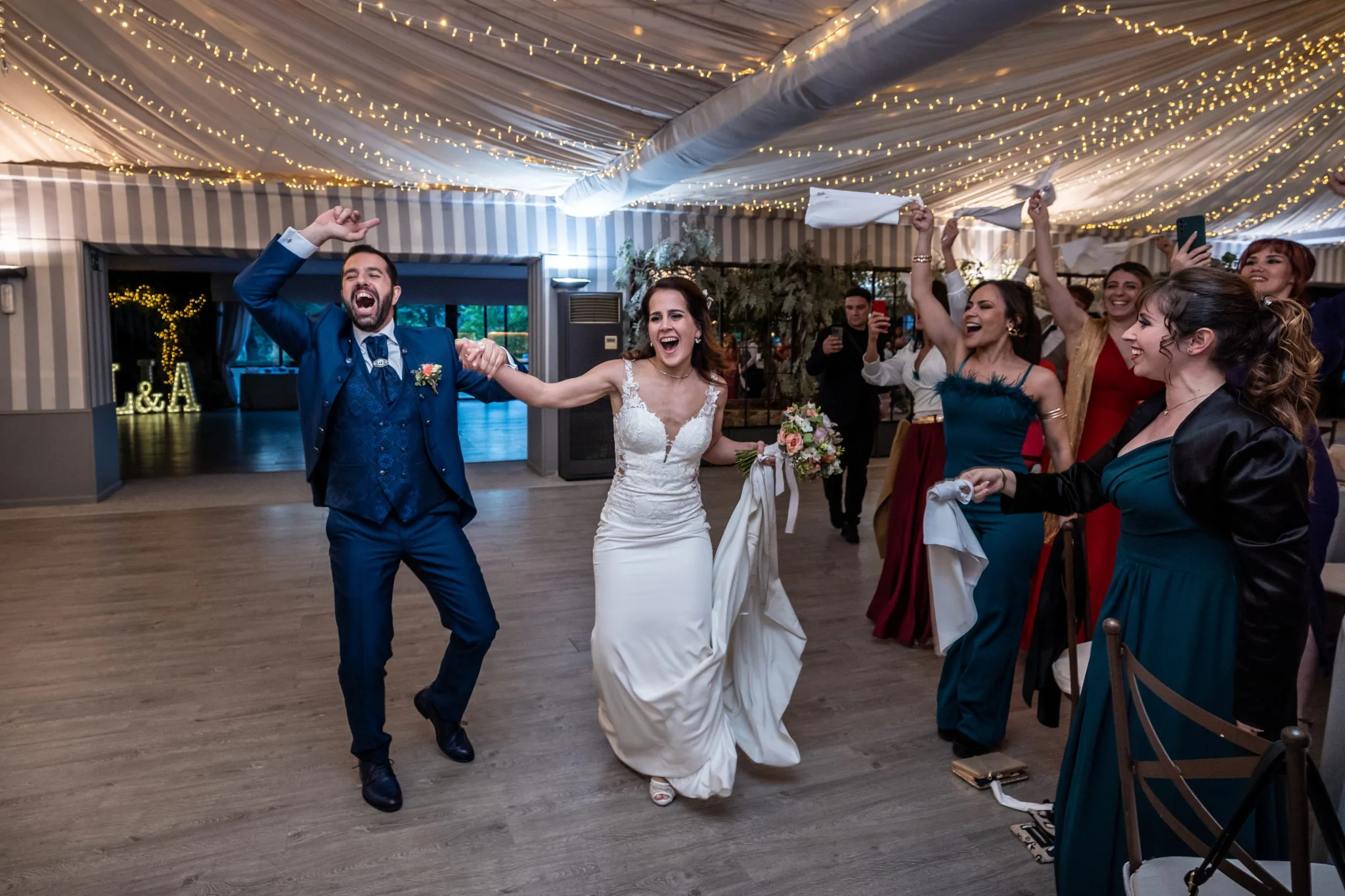 Entrada alegre de los novios acompañados por invitados en una boda en Peñarrubia de Araceli