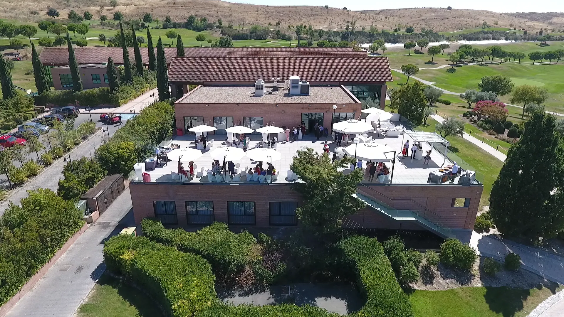 Vista aérea de la terraza del edificio principal montada para un evento, rodeada de jardines de Retamares Experience.