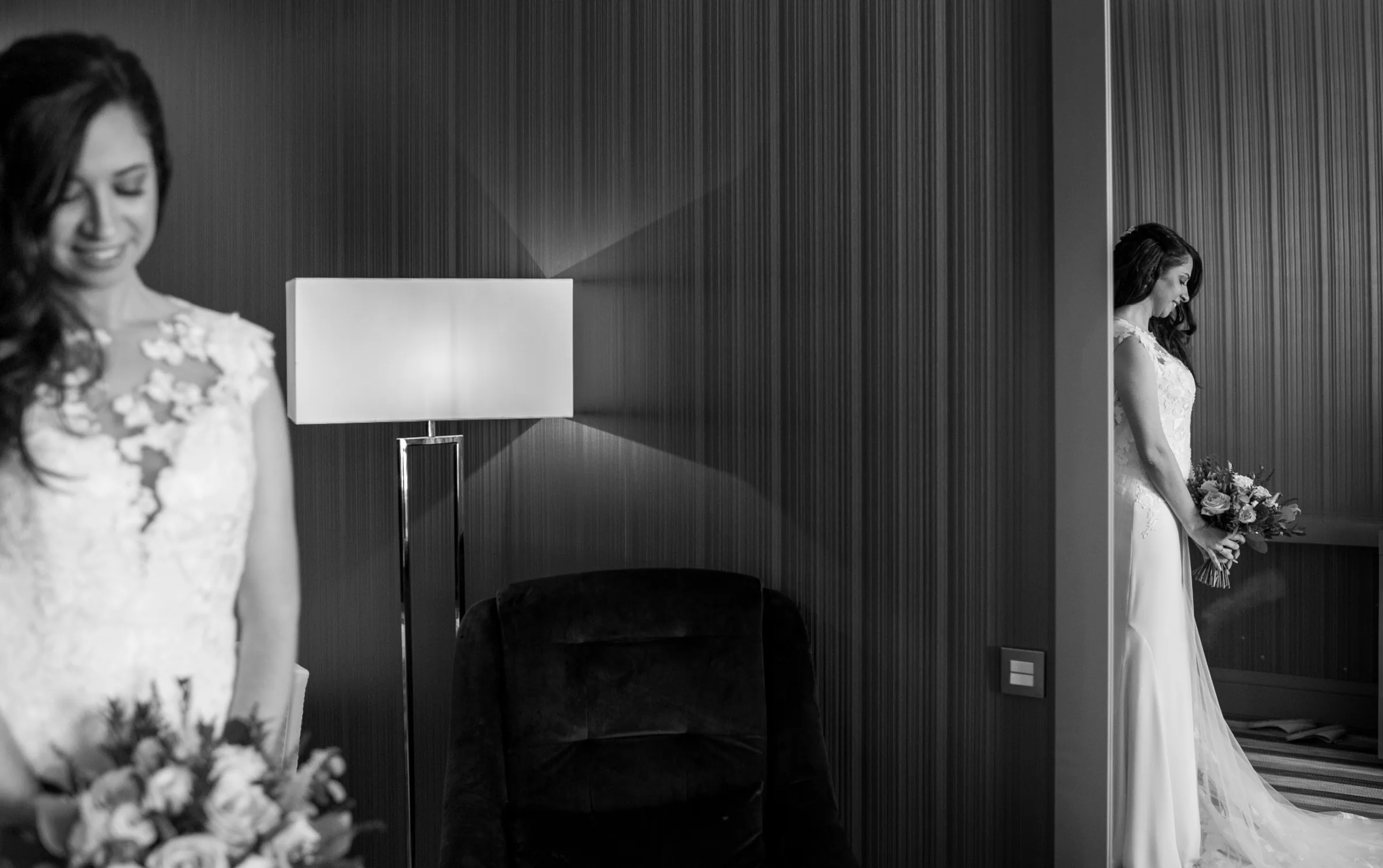 Retrato en blanco y negro de la novia con su ramo junto a una lámpara en la habitación en Retamares Experience.