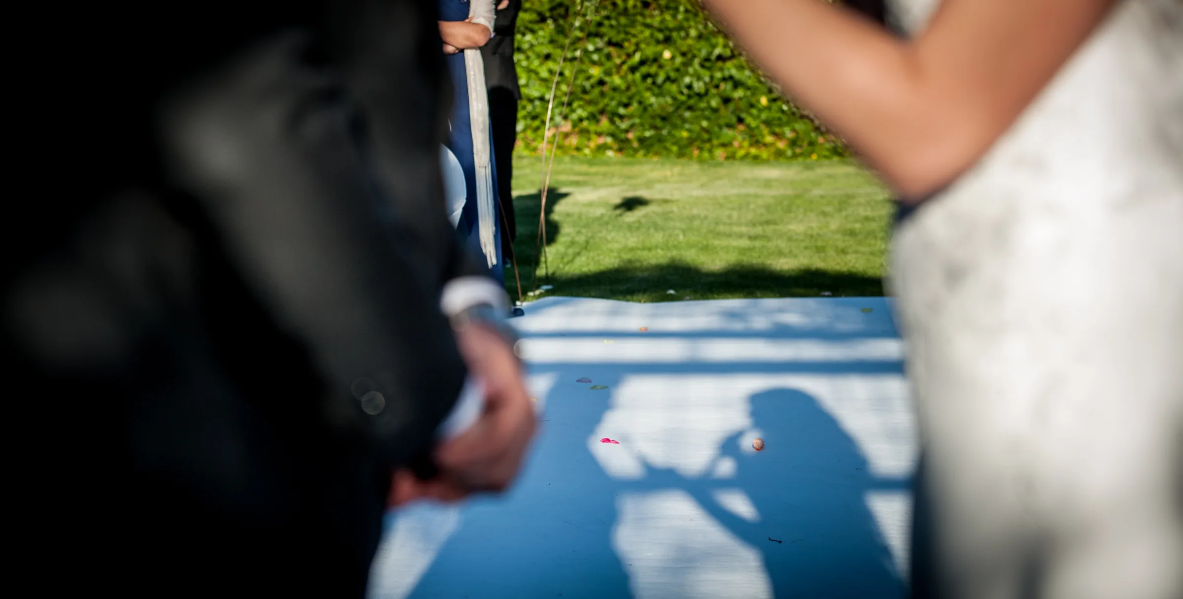 Detalle de las sombras de los novios sobre el suelo junto a la novia y el novio en Retamares Experience.
