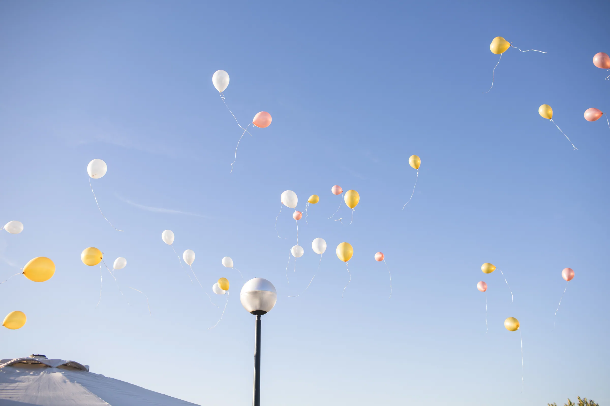 Globos de colores subiendo en el cielo azul tras la ceremonia en Retamares Experience.