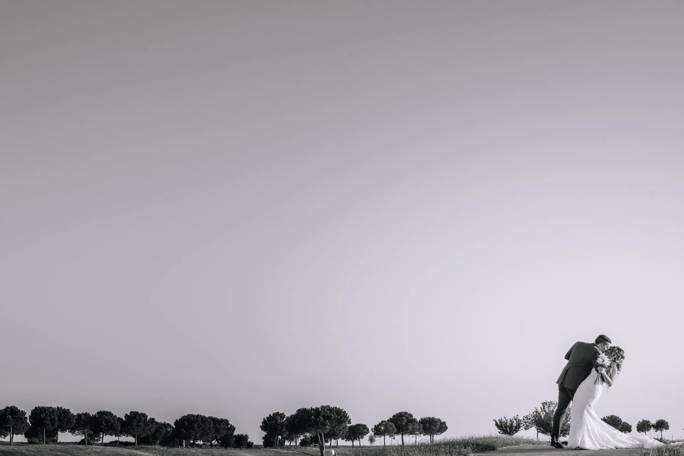 Los novios junto a la línea de pinos del horizonte en blanco y negro en Retamares Experience.