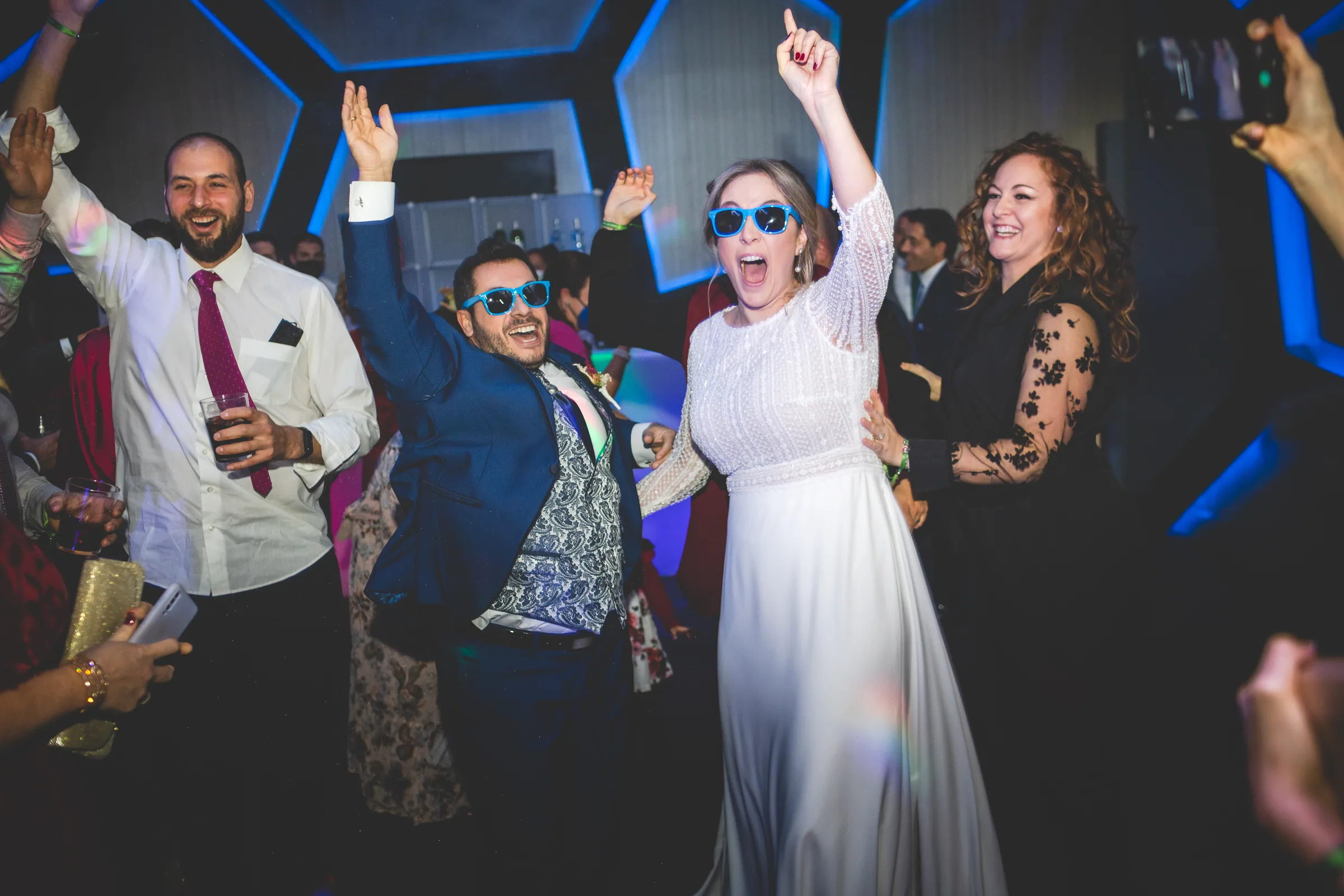 Los novios y los invitados celebran en la pista de baile con gafas de colores en Retamares Experience.