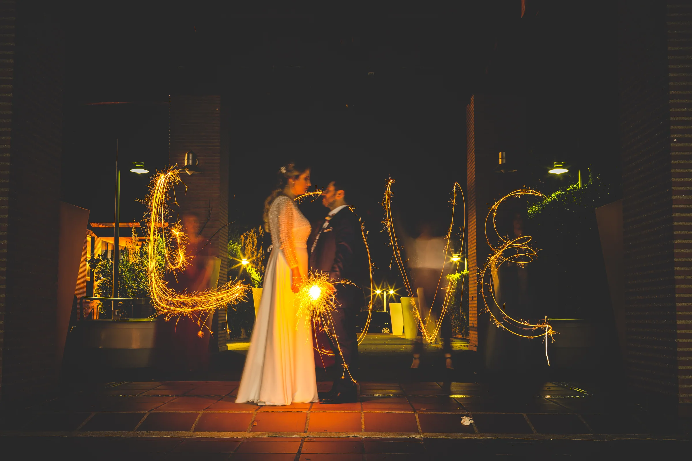 Los novios frente a letras de luz en la sesión nocturna en Retamares Experience.