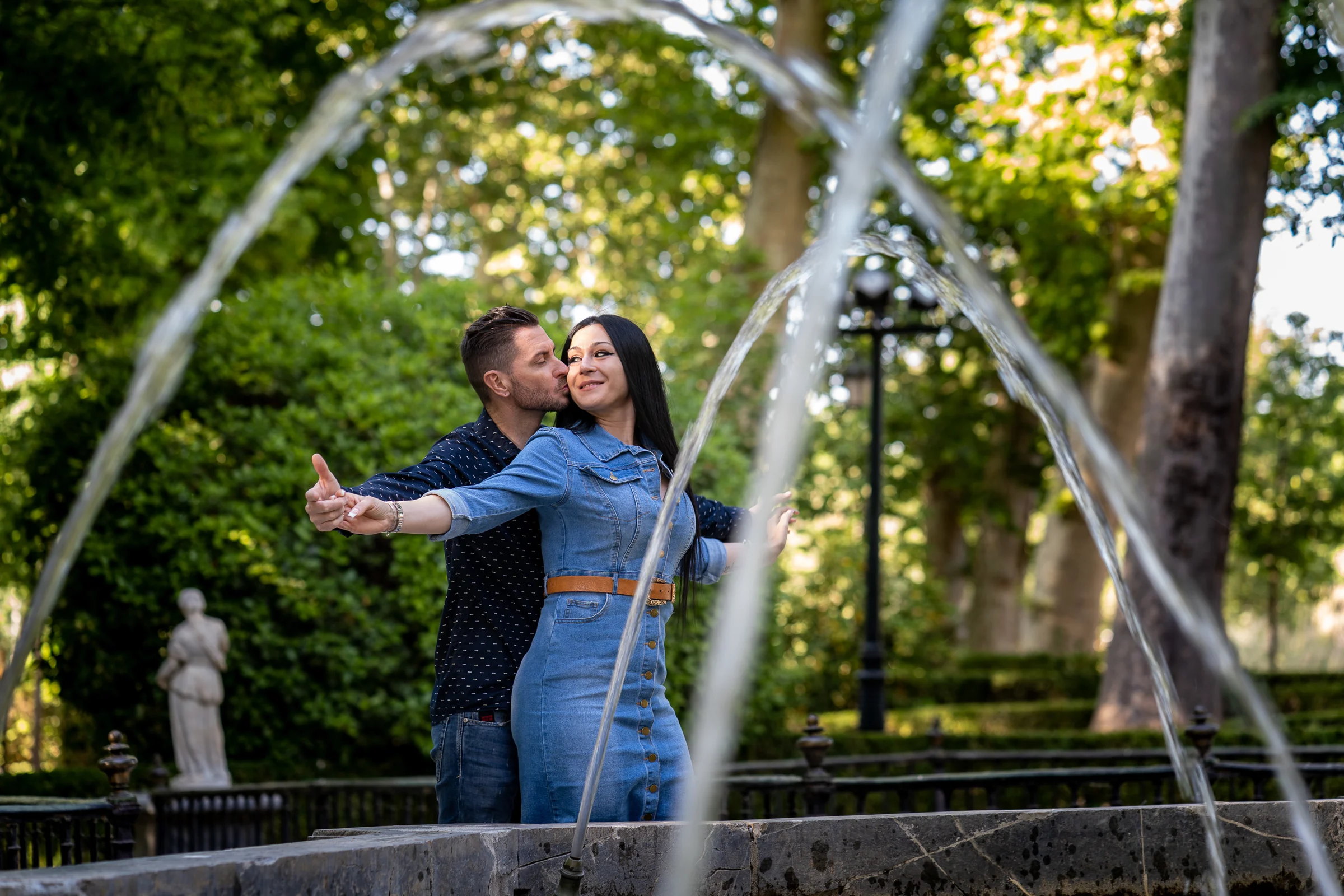 Sara y Edu se abrazan entre árboles y vegetación durante su sesión de preboda en los jardines de Aranjuez.