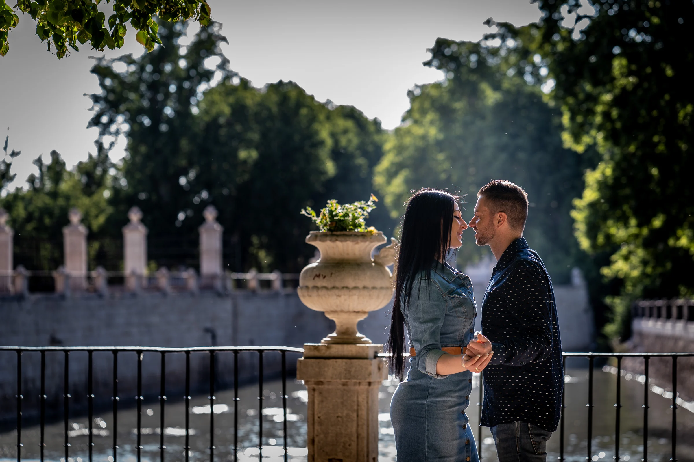 Sara y Edu conversan junto a una urna ornamental en los jardines de Aranjuez durante su preboda.