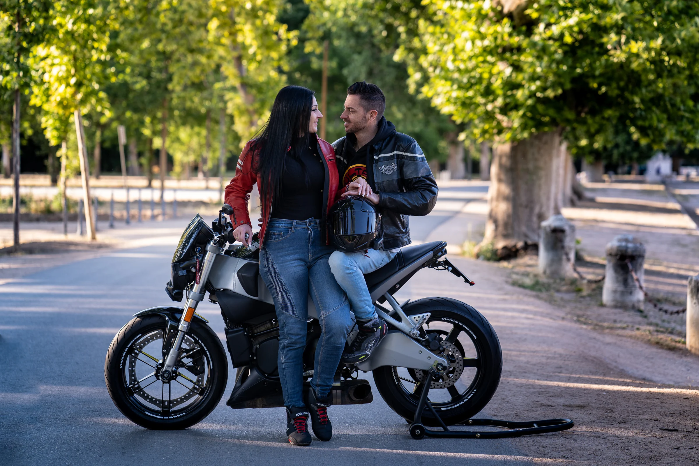 Sara y Edu posan junto a una moto durante su preboda en Aranjuez, incorporando una de sus grandes pasiones a la sesión.