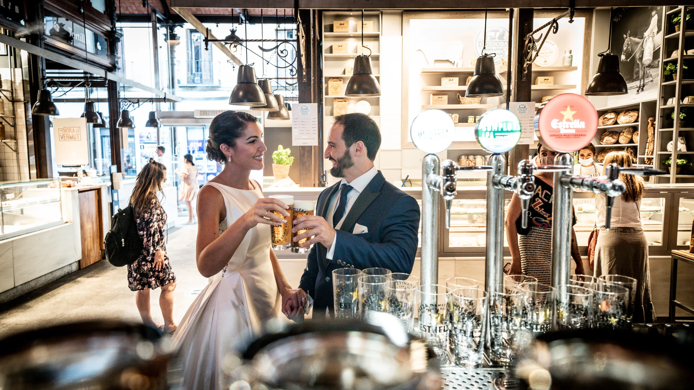 Sara y Edu brindan dentro del Mercado de San Miguel durante su postboda por el Madrid de los Austrias.