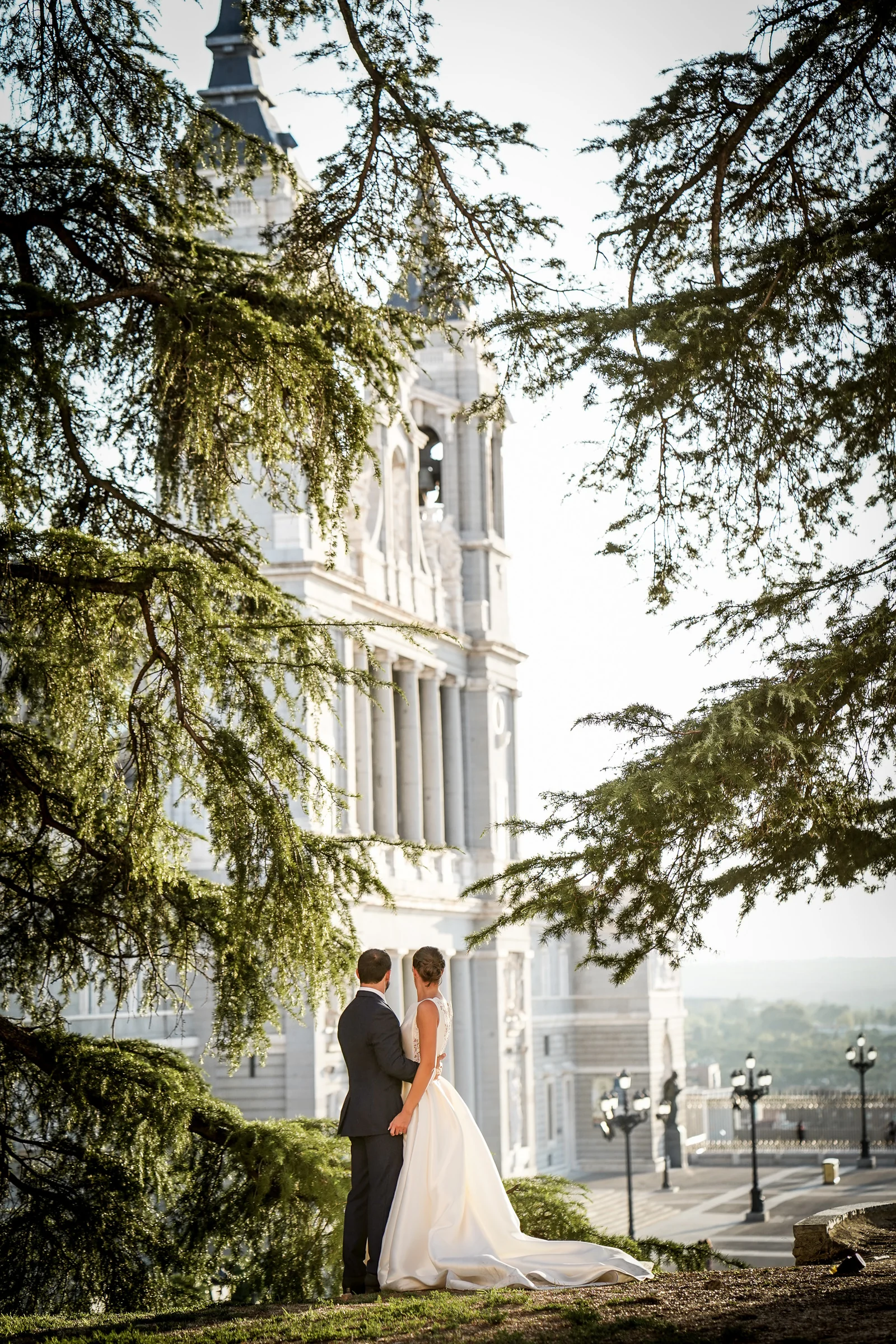 Sara y Edu aparecen entre los árboles con la Catedral de la Almudena al fondo durante su postboda por Madrid.