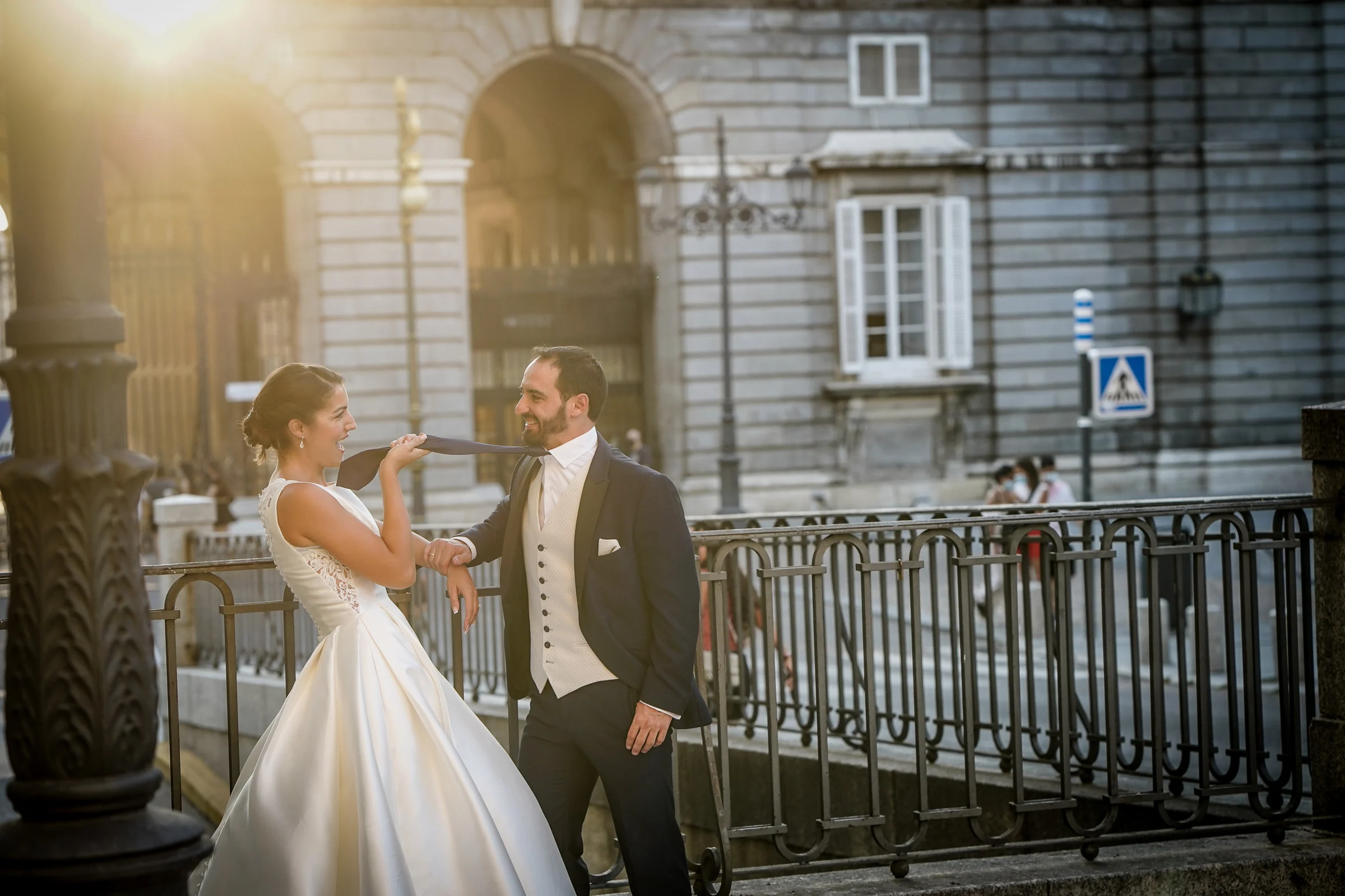 Sara juega con la corbata de Edu junto a una barandilla del Palacio Real durante su postboda en Madrid.