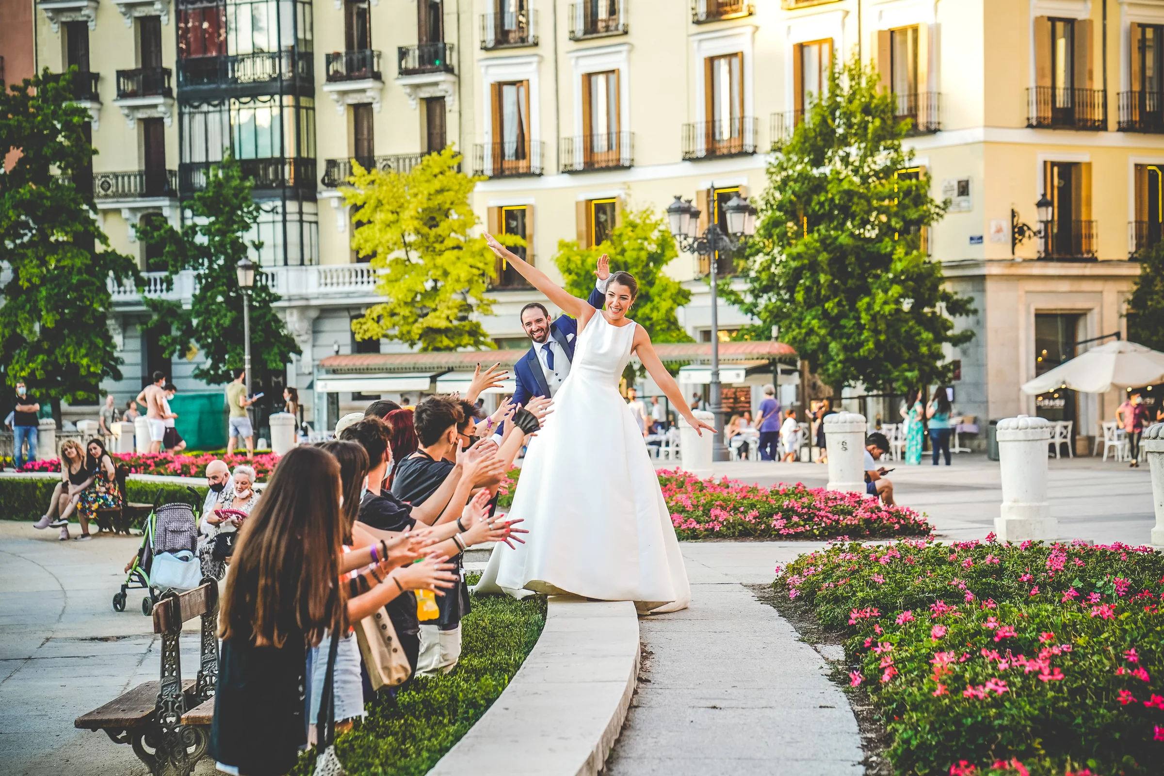 Sara y Edu juegan con un grupo de personas en la Plaza de Oriente durante su postboda por el centro de Madrid.