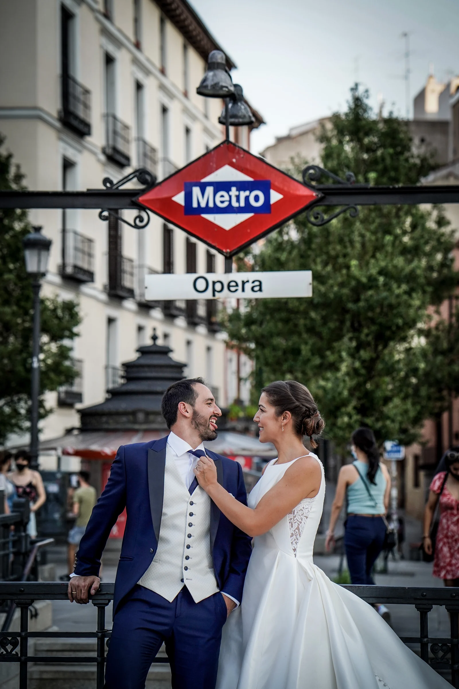 Sara y Edu posan bajo el rótulo de Metro Ópera durante su recorrido de postboda por el centro de Madrid.