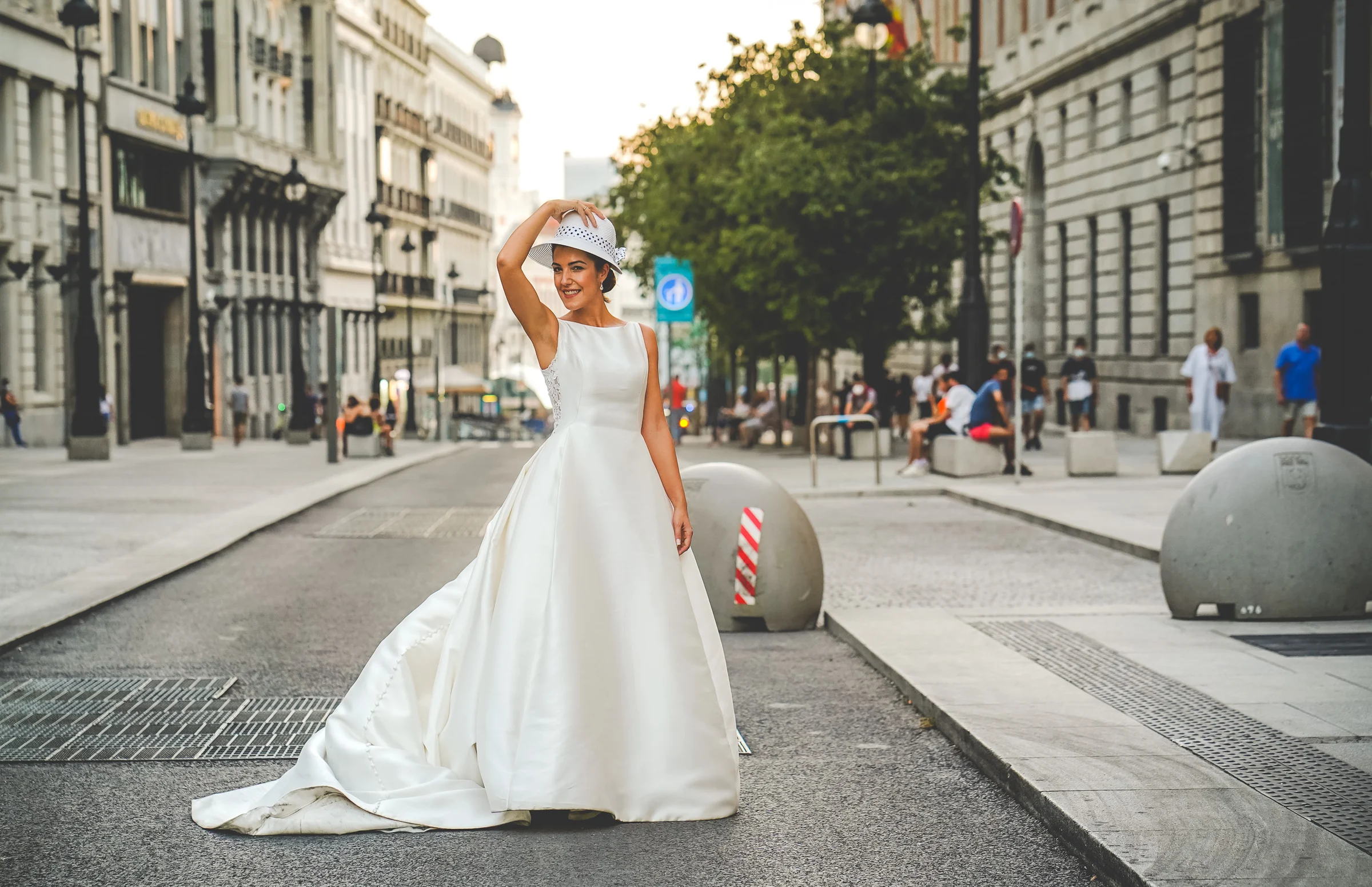 Sara posa sola con un sombrero en una calle peatonal del centro de Madrid durante su sesión de postboda.